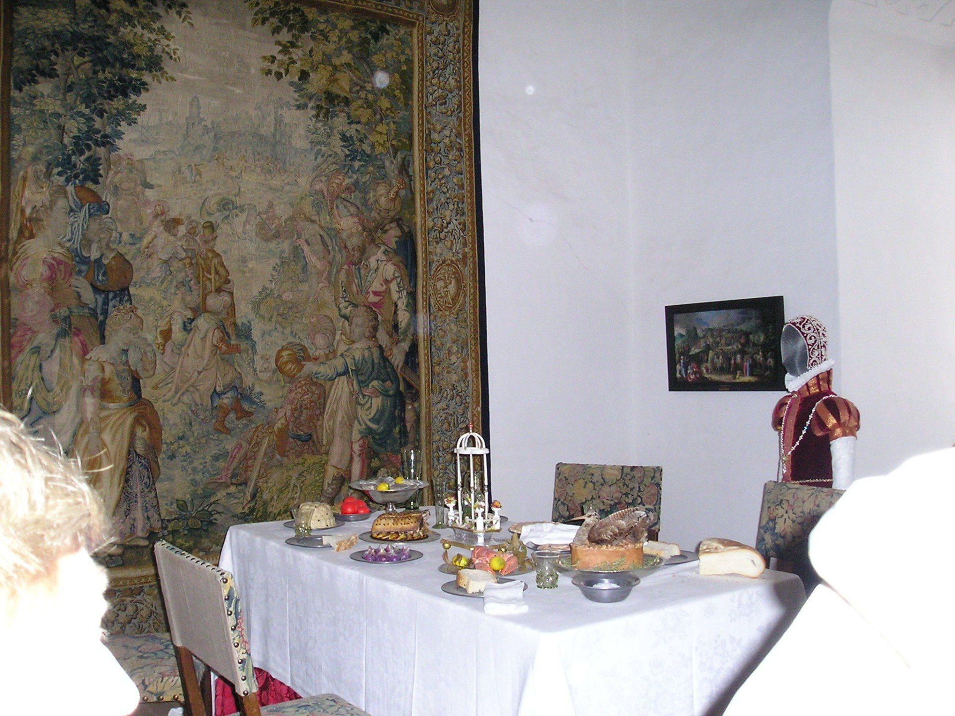 A table in a room with a painting on the wall behind it