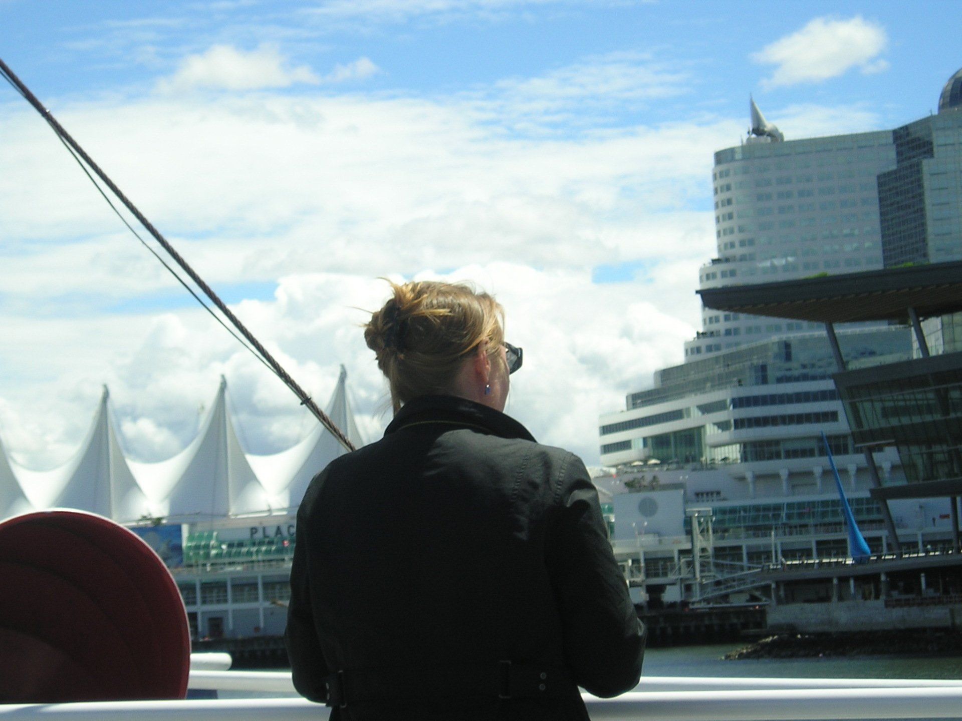 A woman in a black jacket looks out over a body of water