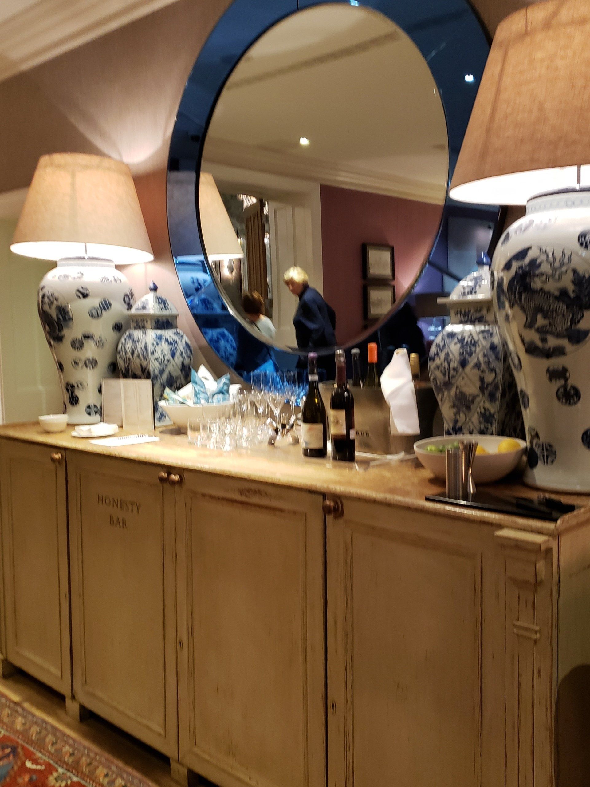 A dining room with a large mirror and lamps