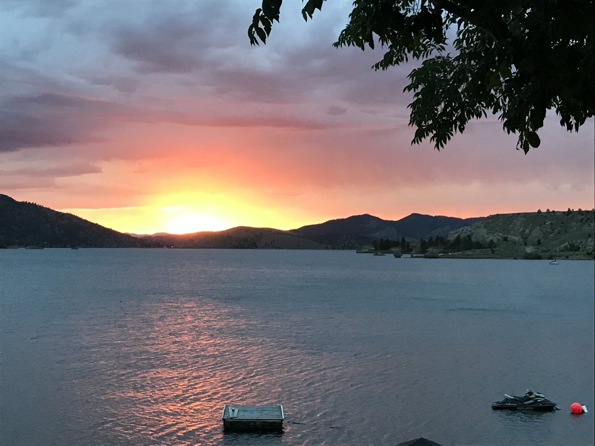 A sunset over a lake with mountains in the background
