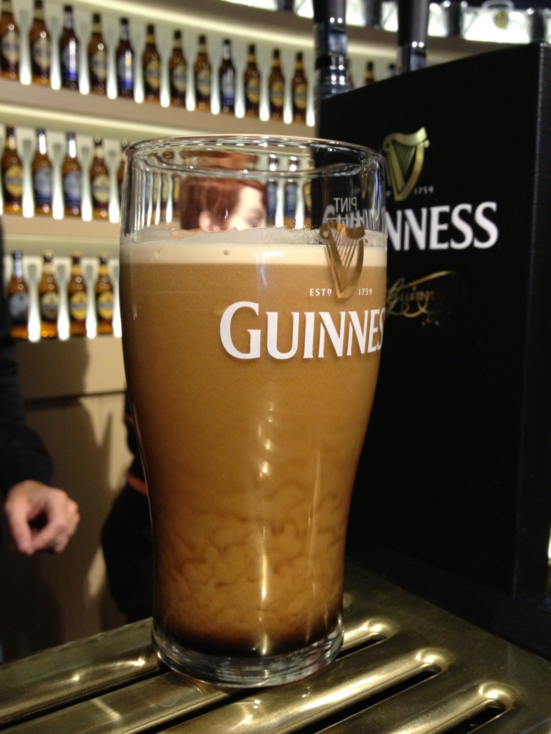 A glass of guinness sits on a bar