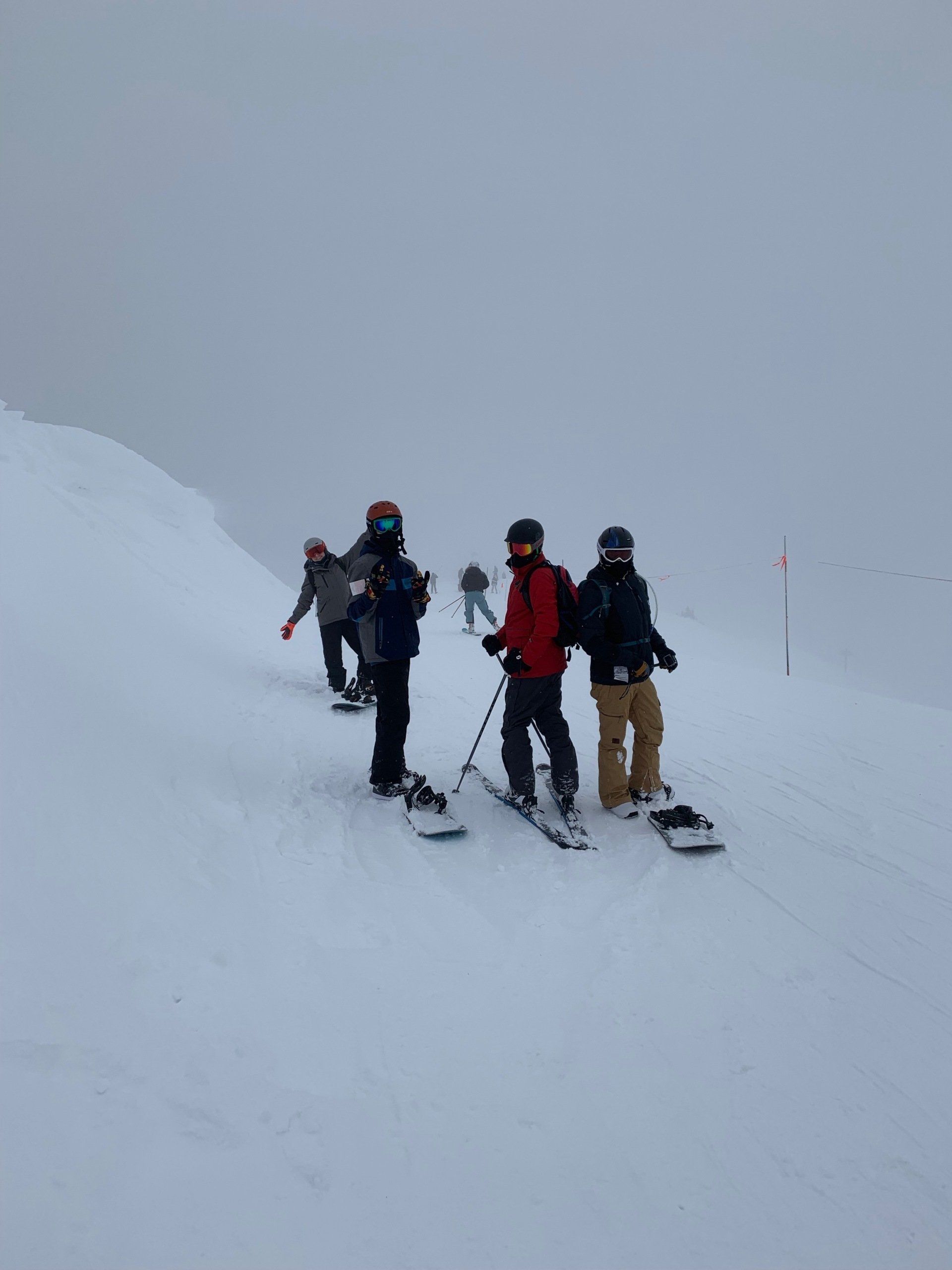 A group of people are standing on top of a snow covered mountain.
