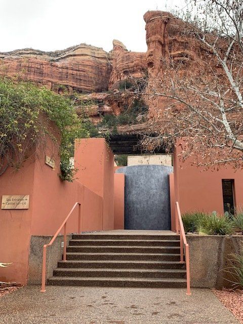 Stairs leading up to a building with a large rock in the background
