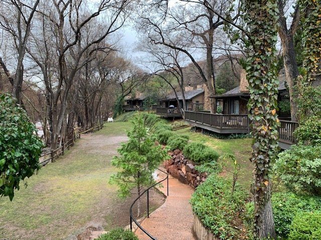 A path leading to a house surrounded by trees and bushes.