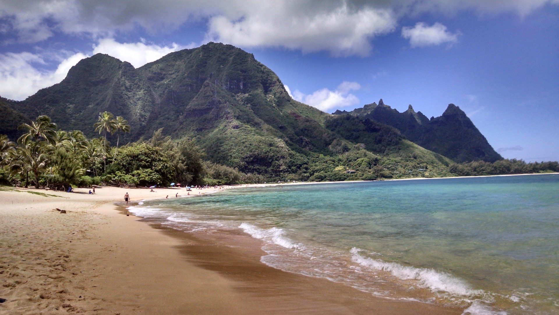 A beach with mountains in the background and a body of water