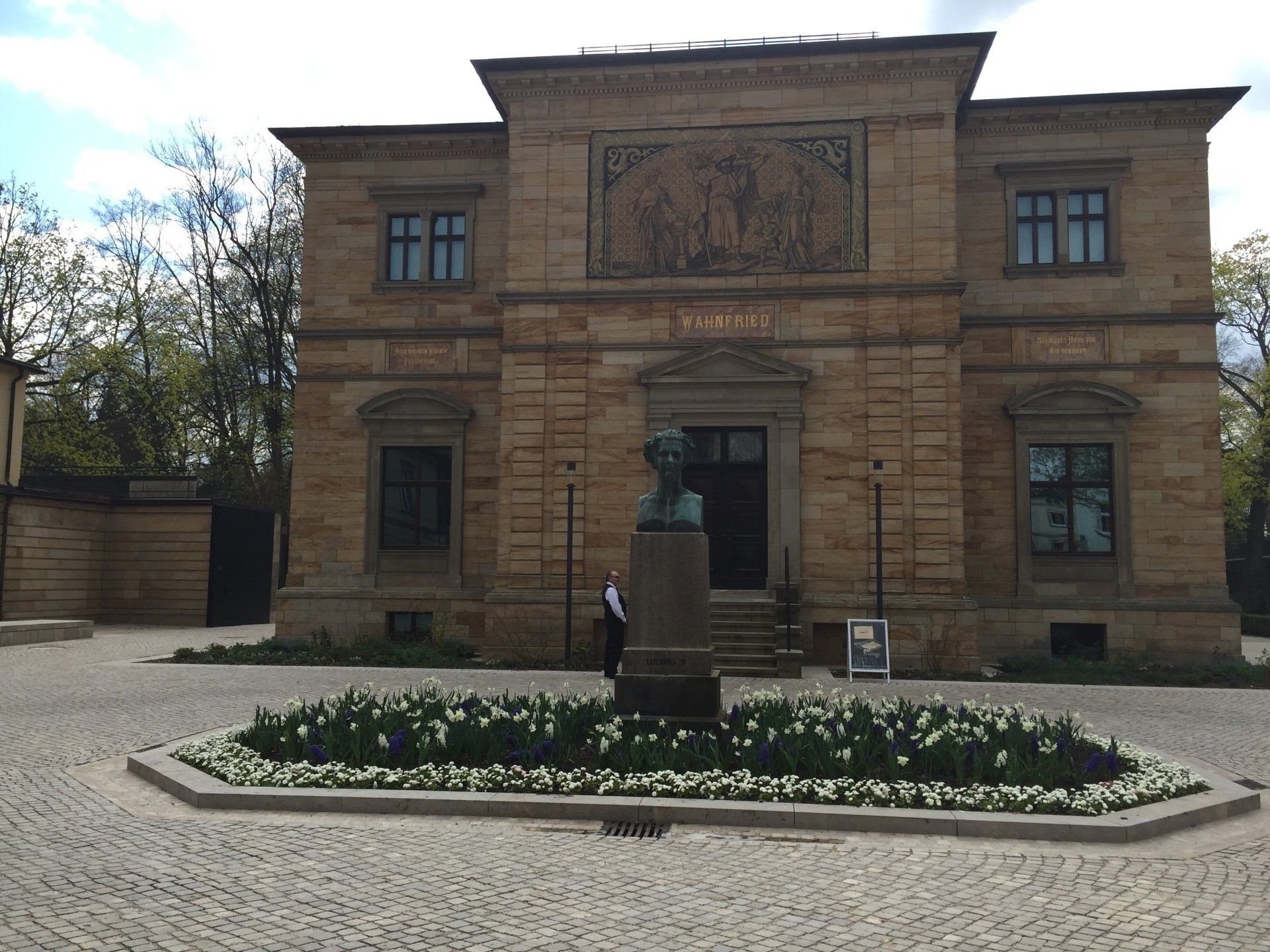A large brick building with a statue in front of it