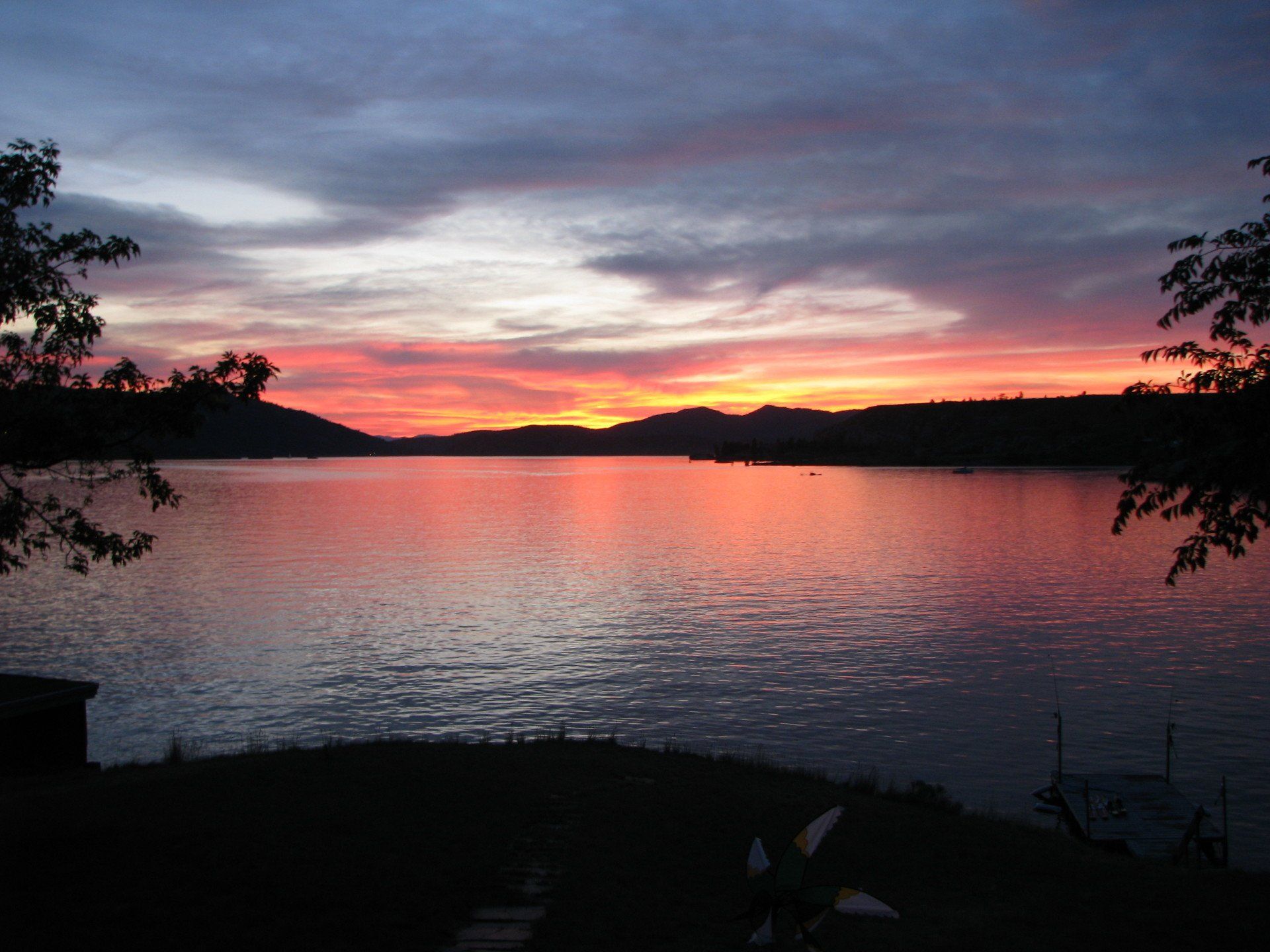 A sunset over a lake with mountains in the background