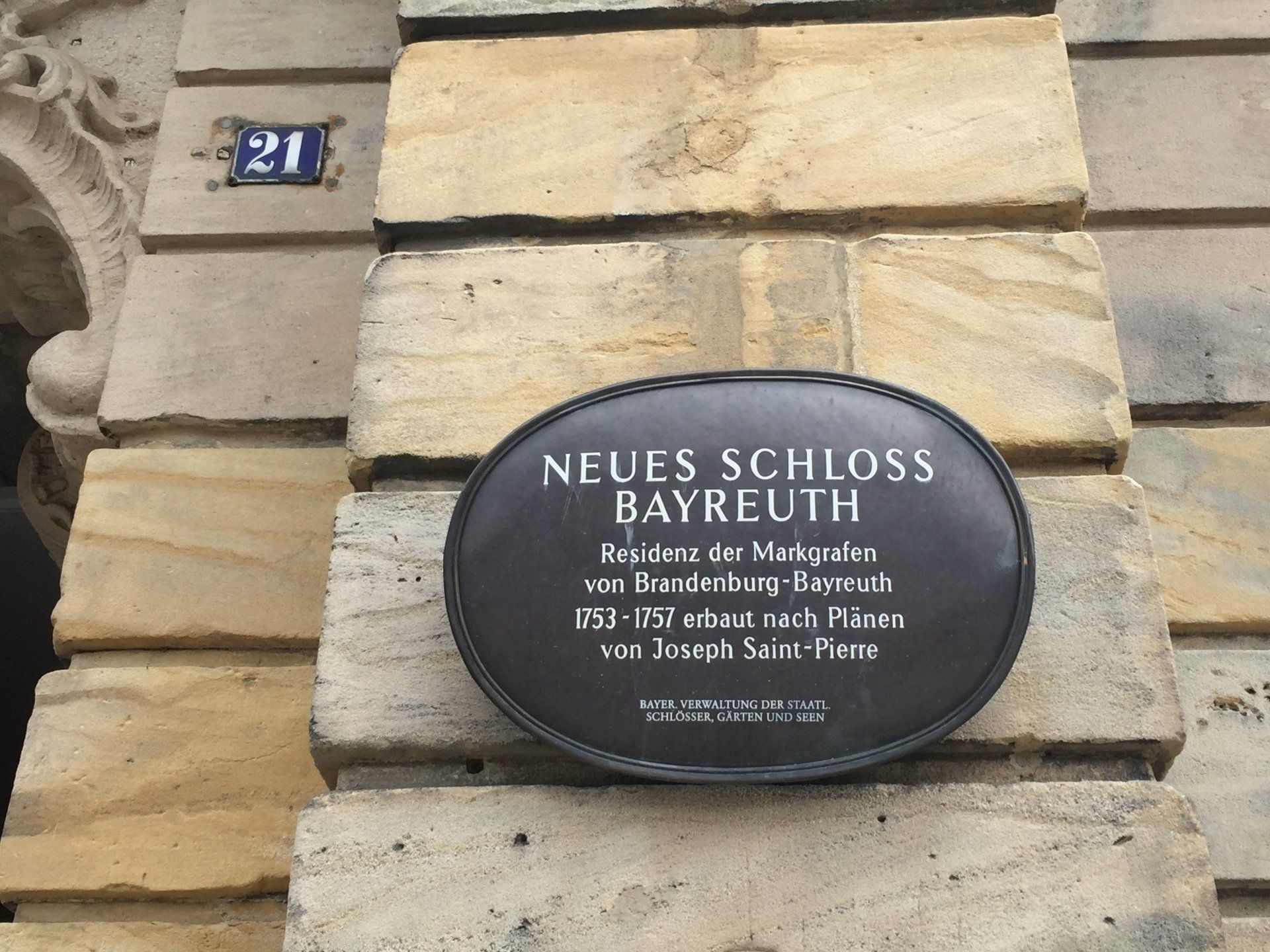 A plaque on the side of a building says neues schloss bayreuh