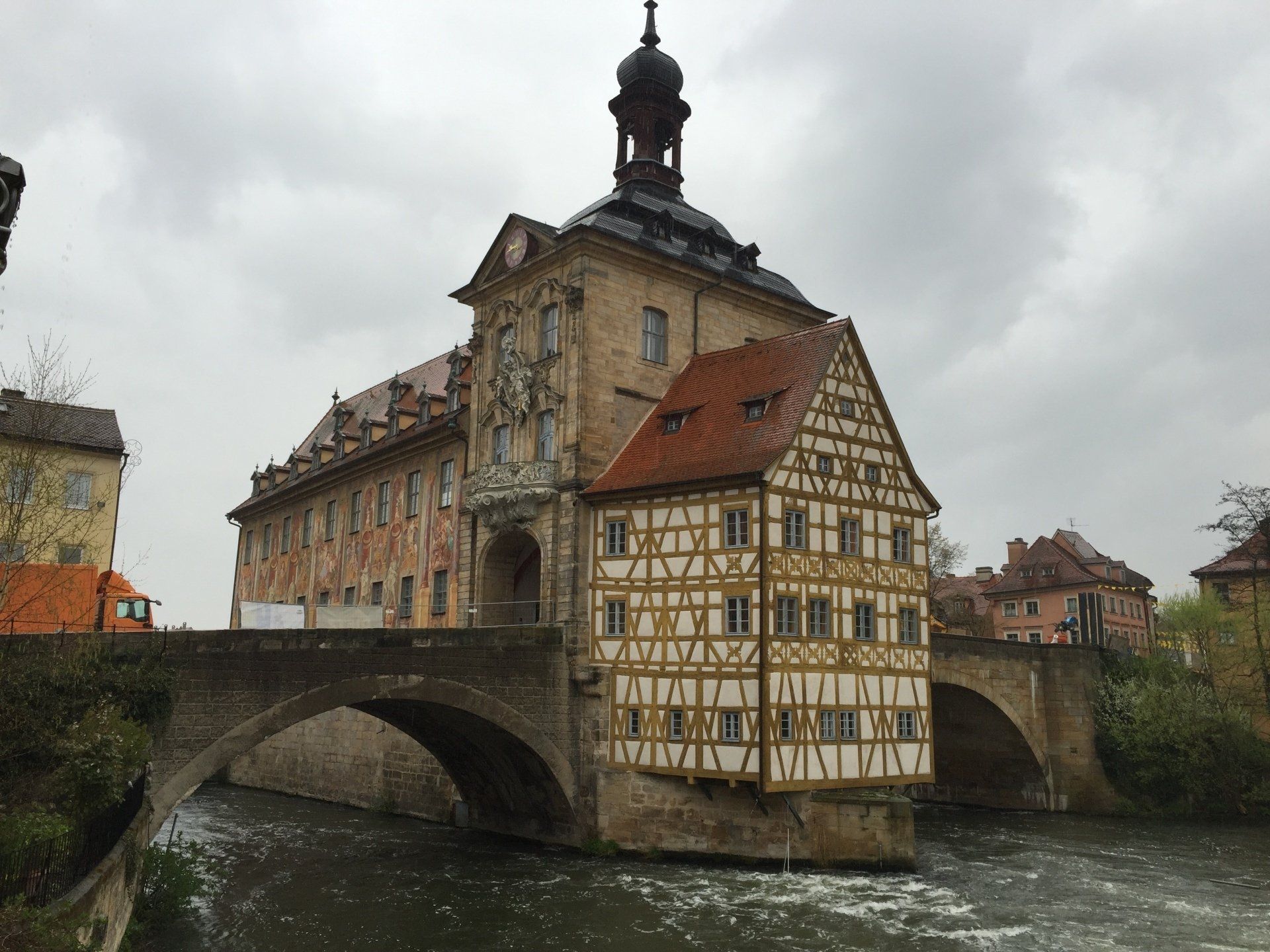 A bridge over a river with a large building in the background