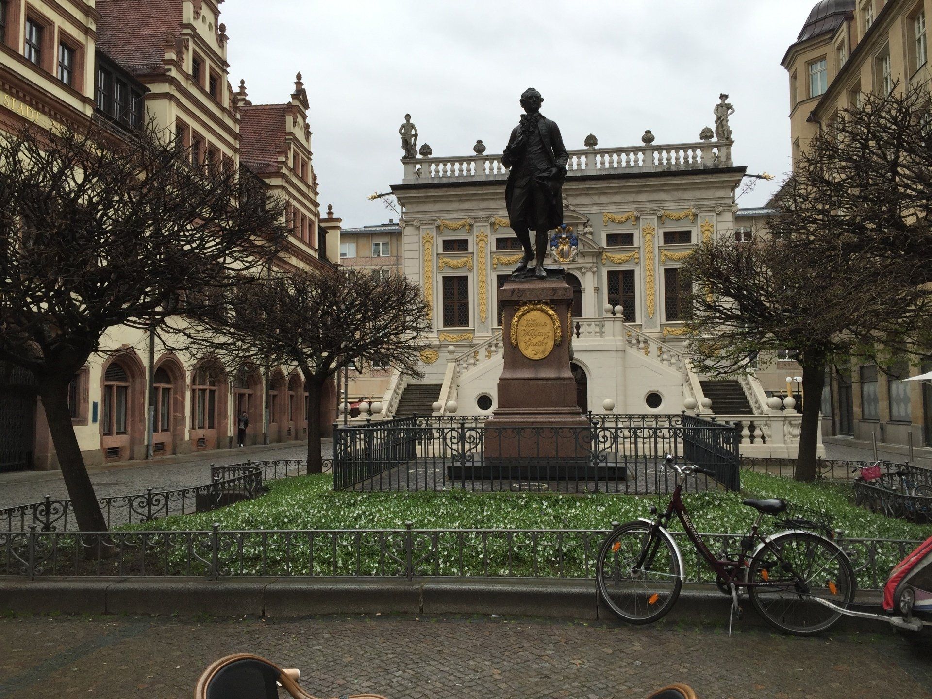 A statue of a man on a horse in front of a building