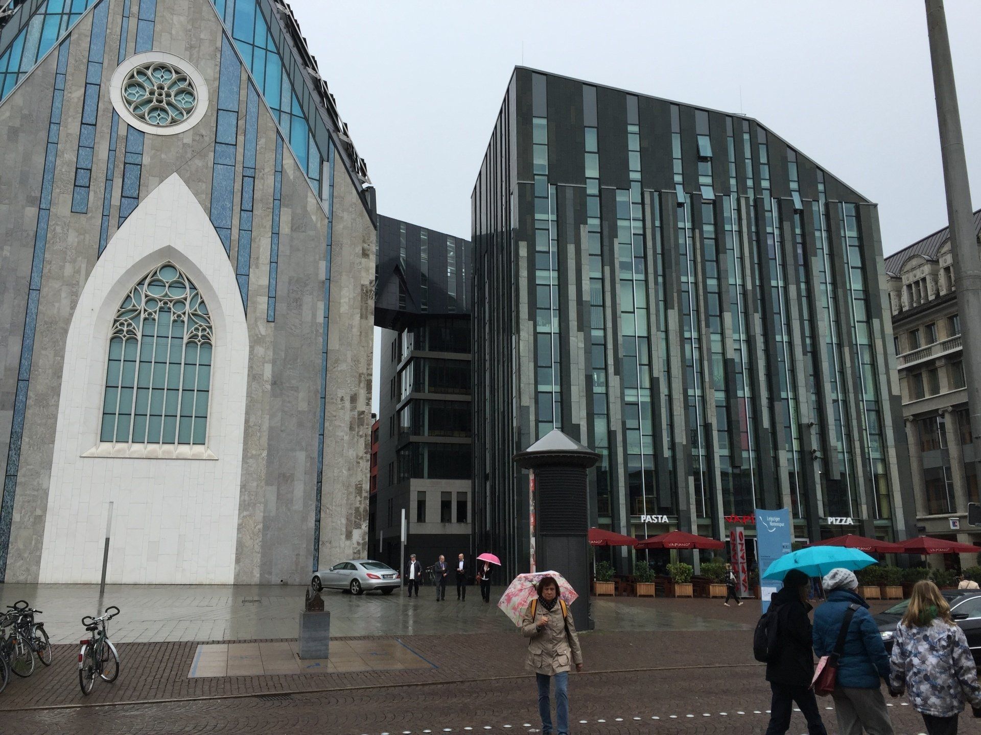 A group of people walking in front of a large building