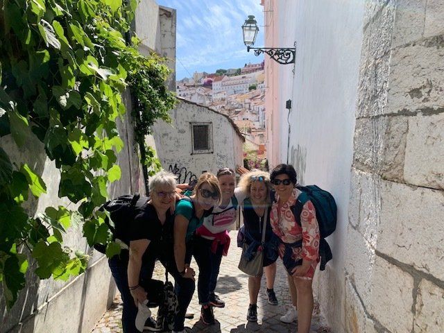 A group of women are posing for a picture in a narrow alleyway.