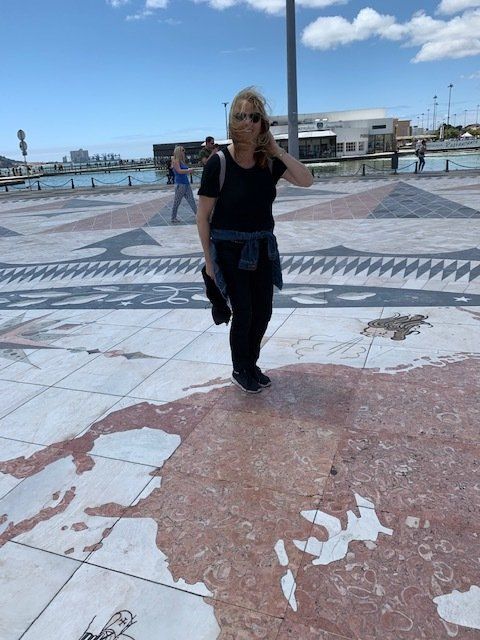 A woman standing in front of a map of the world