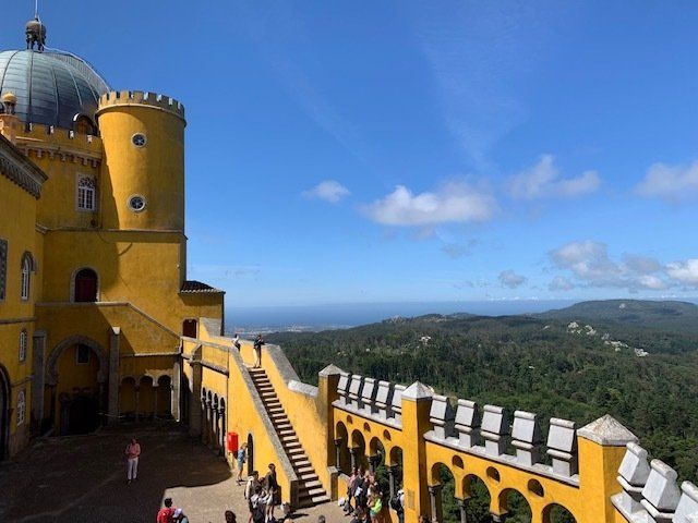 A yellow castle with a dome on top of it