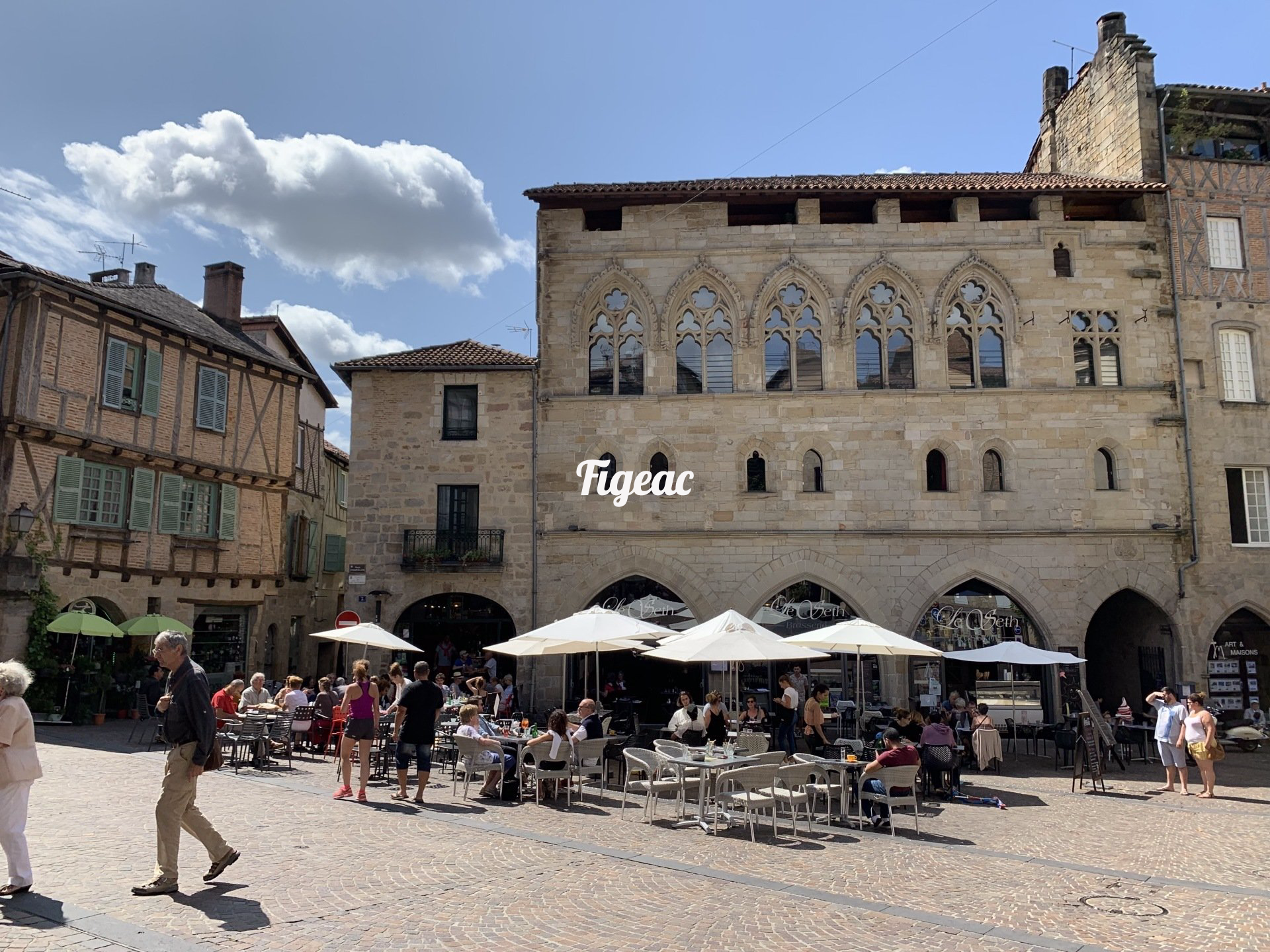A group of people are walking in front of a large building.