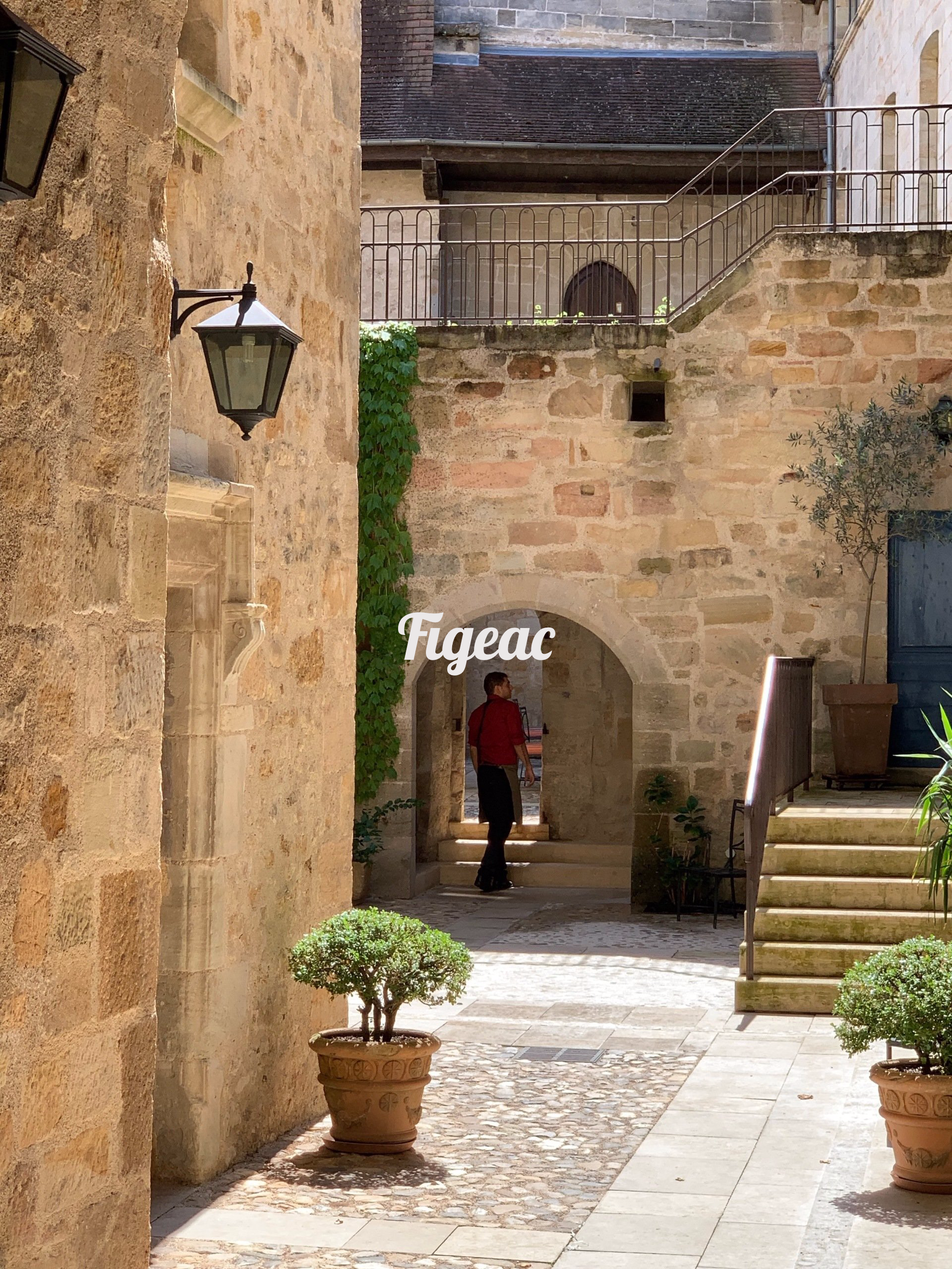 A man is walking down a narrow alleyway between two buildings.