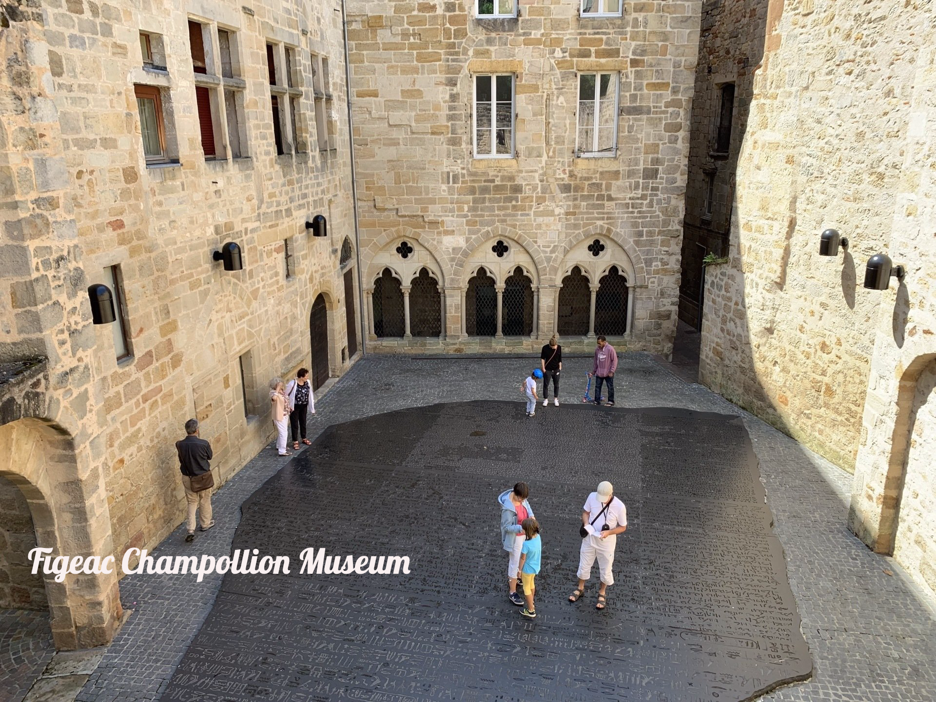 A group of people are standing in the courtyard of a castle.