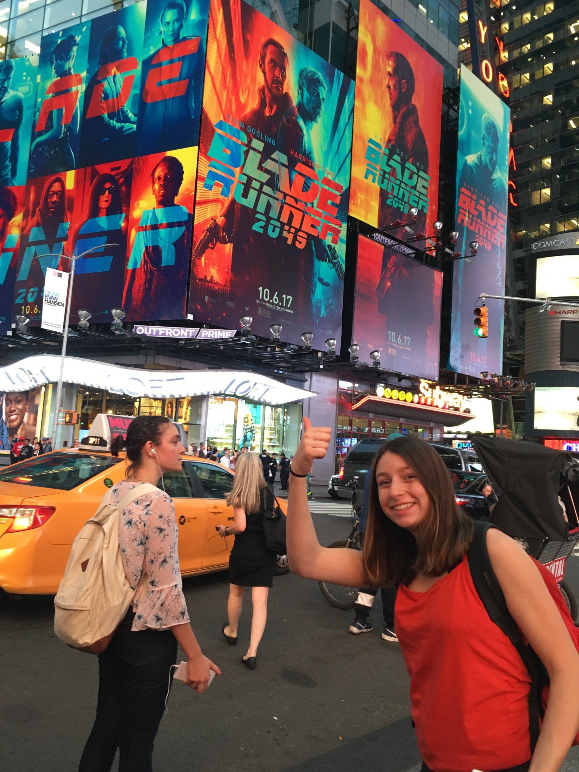 A woman giving a high five in front of a movie poster for blade runner