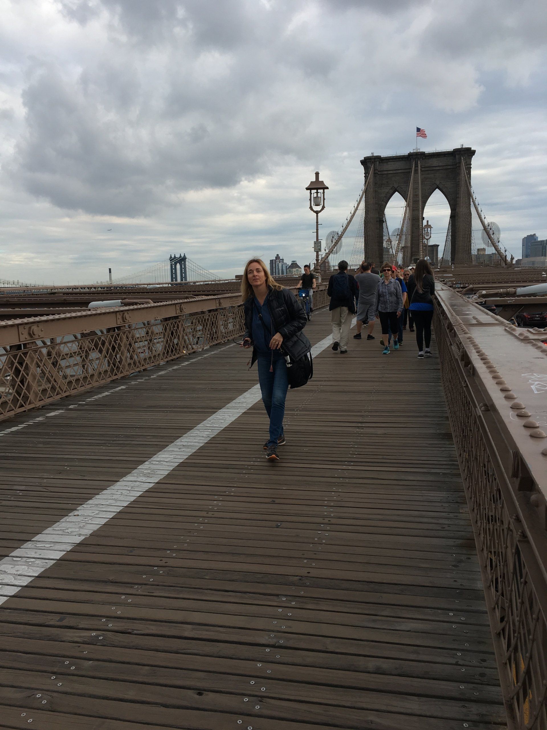 A woman is walking across a bridge in new york city