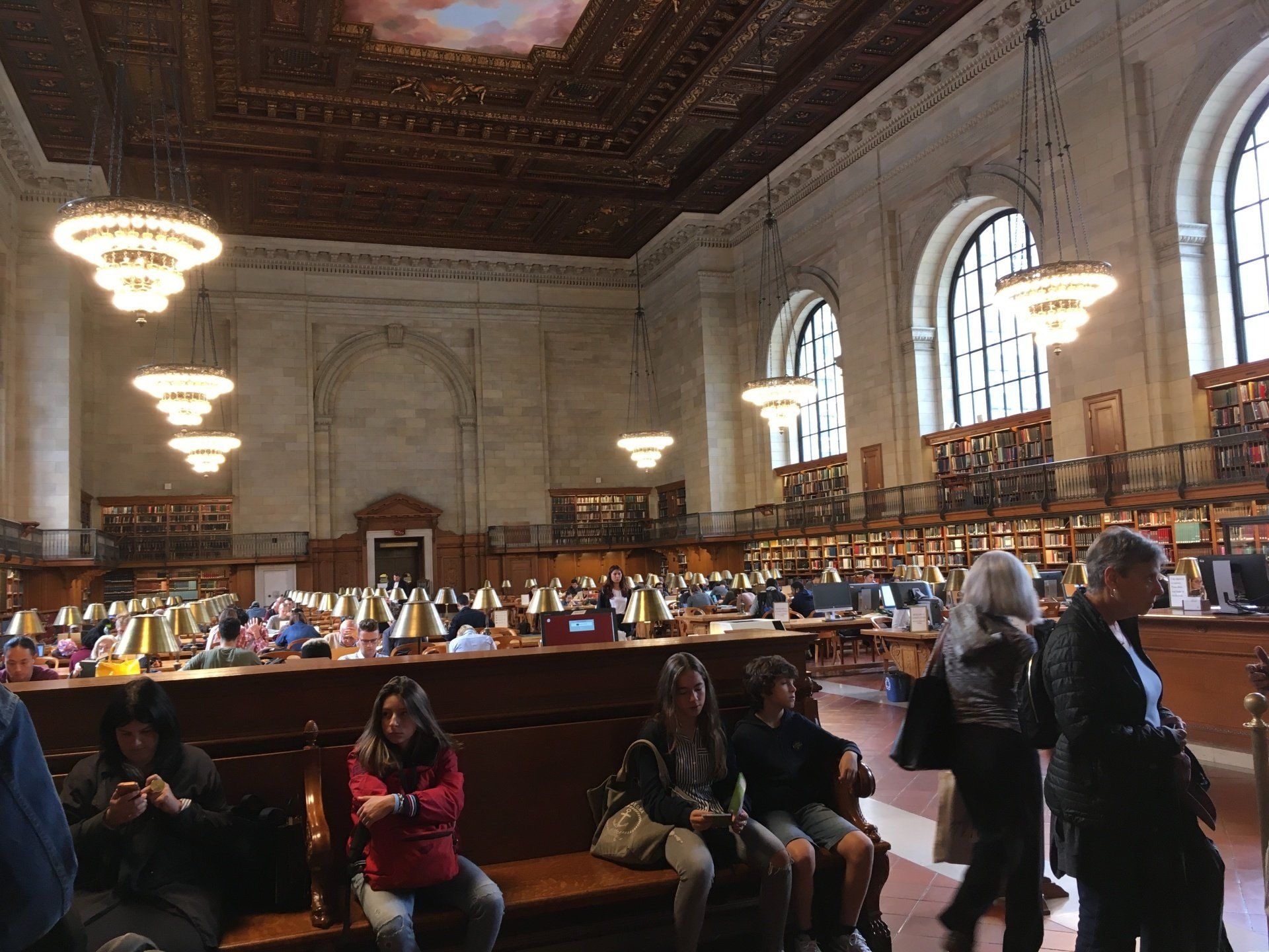 A group of people are sitting on benches in a library.
