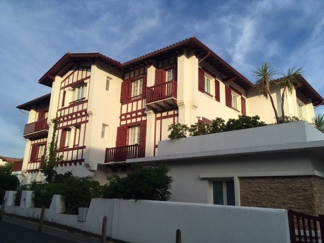 A large white house with red trim and balconies