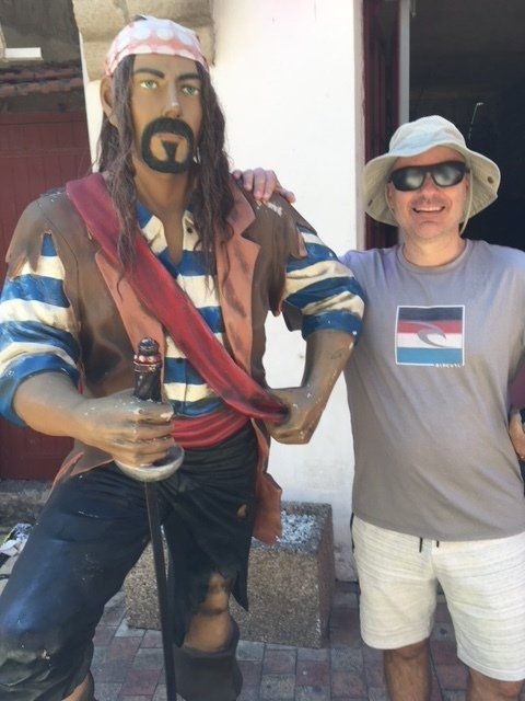 A man standing next to a statue of a pirate