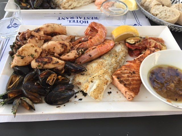 A plate of seafood is on a table in front of a sign that says hotel restaurant