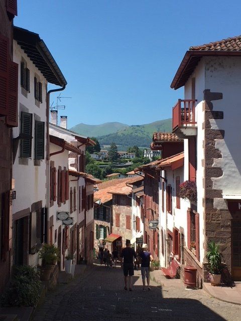 People walking down a narrow street between two buildings