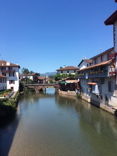 A bridge over a river surrounded by buildings on a sunny day