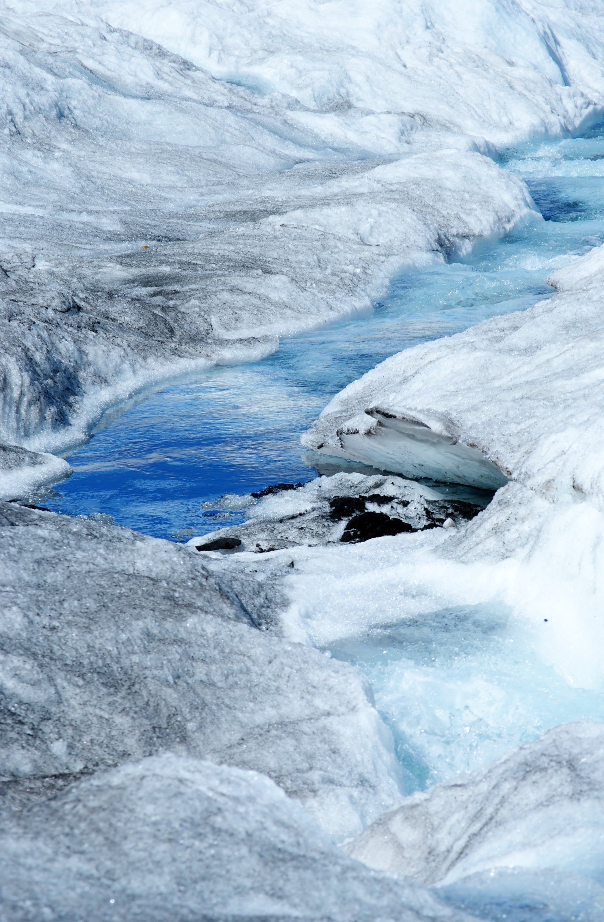 A close up of a river running through a snowy landscape.