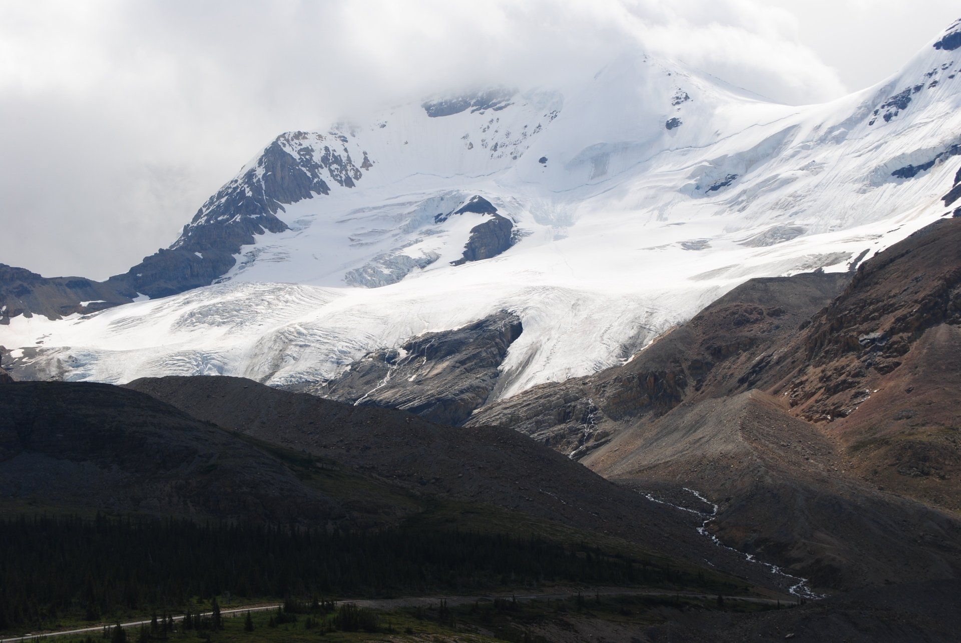 A snowy mountain with a road in the foreground