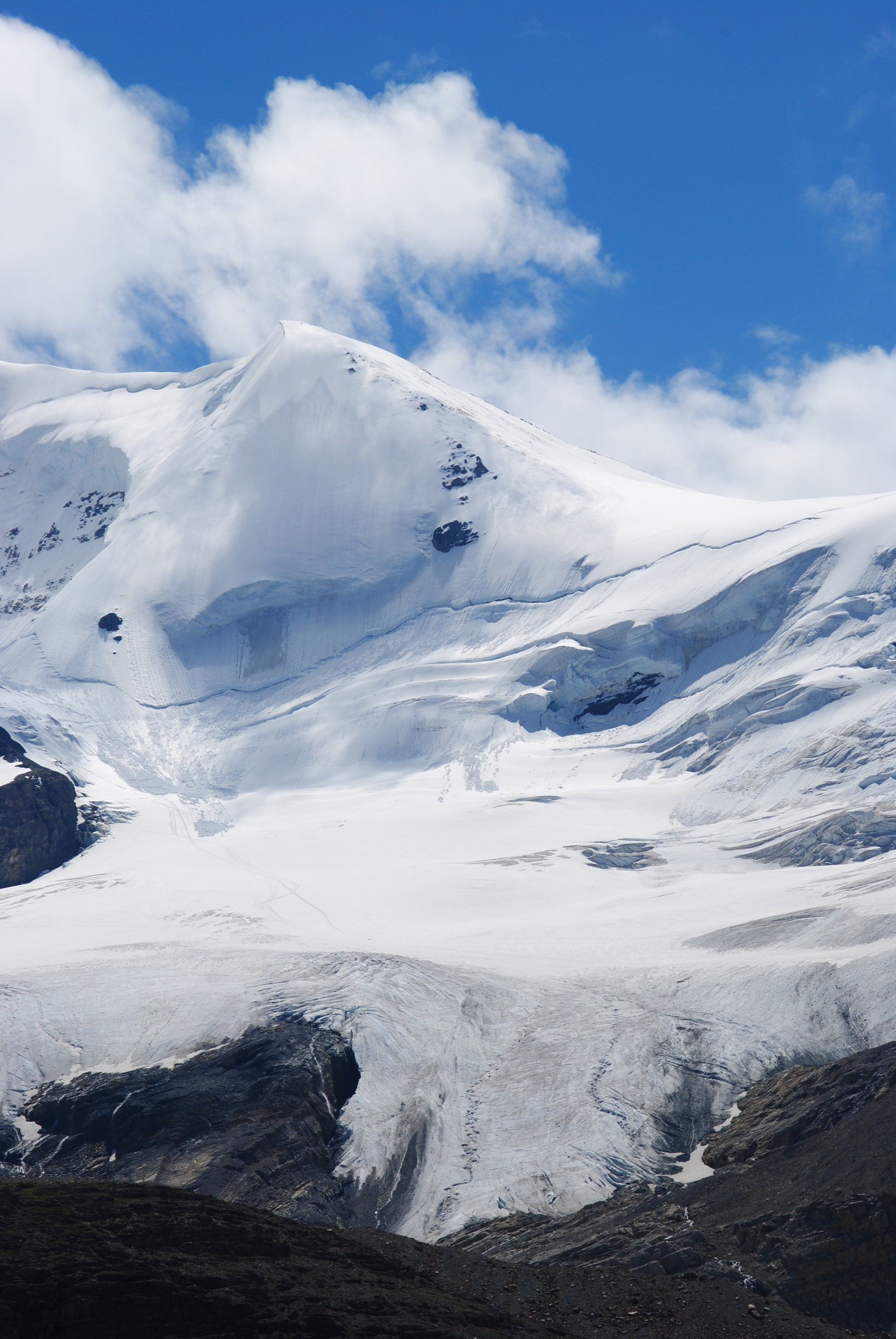 A snowy mountain with a blue sky in the background