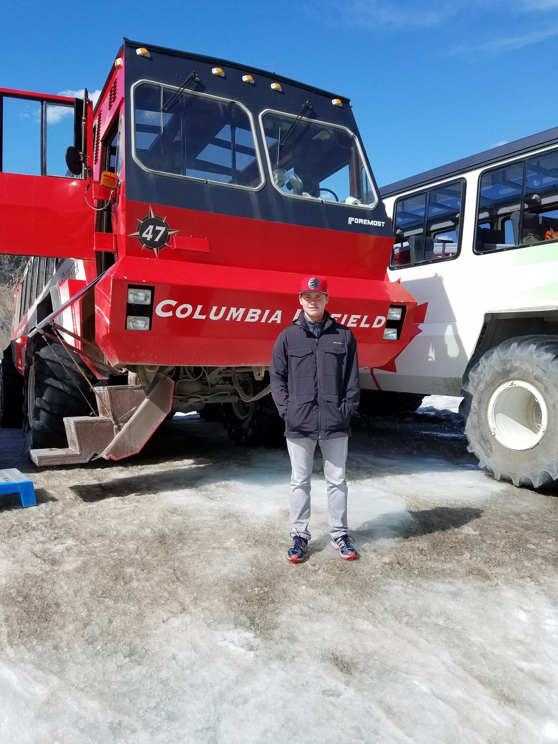 A man standing before huge trucks