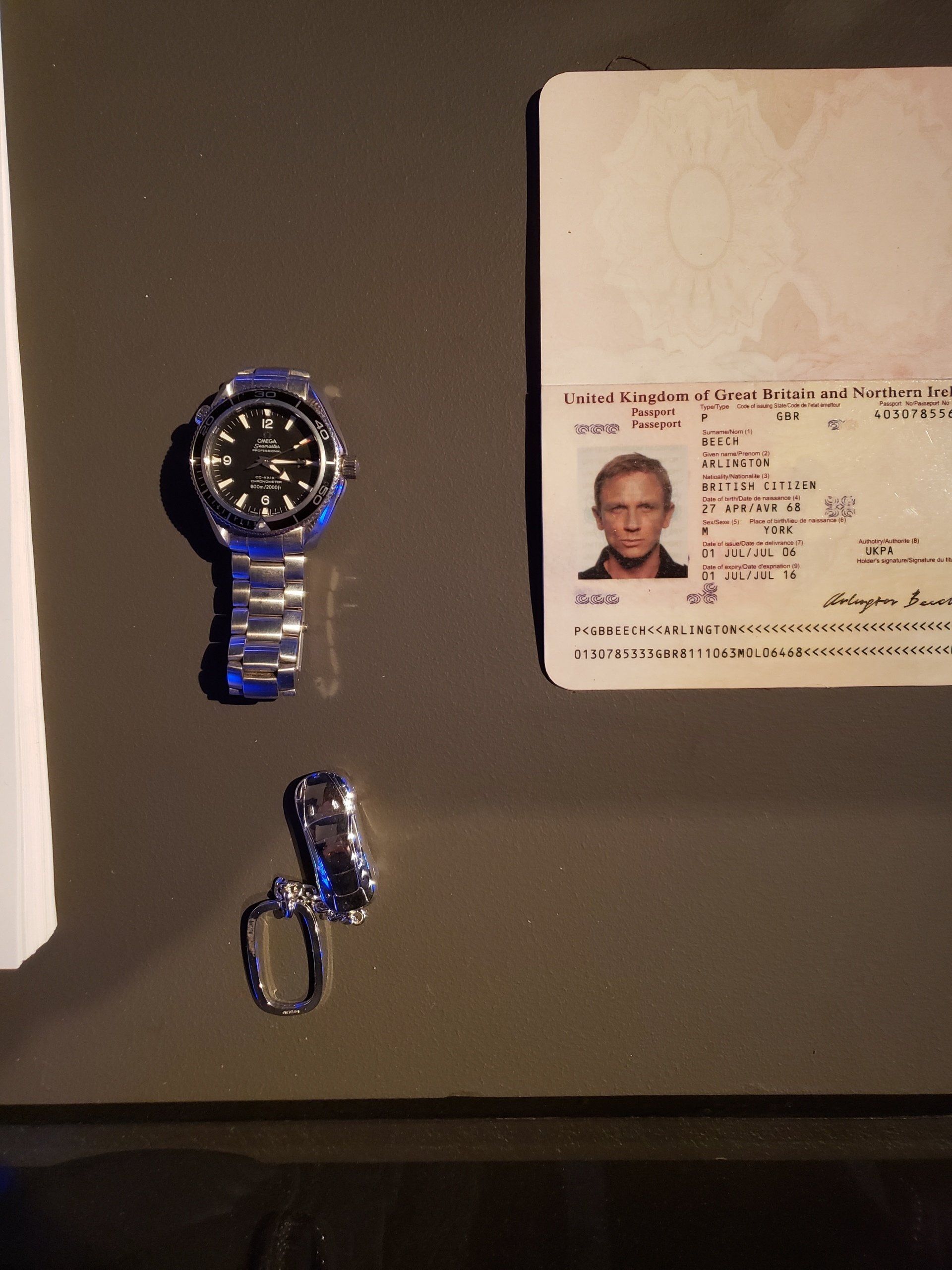 A watch a ring and a passport are on a table