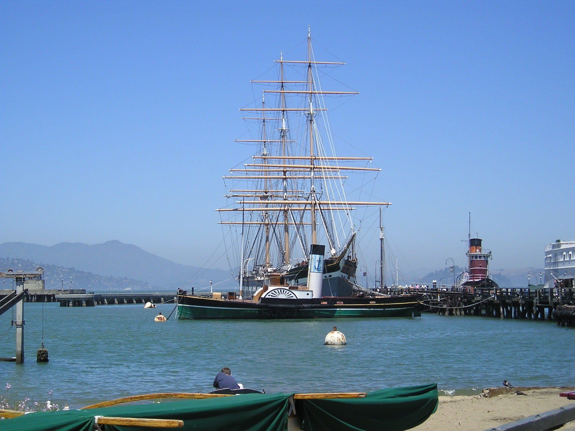 A large sailboat is docked in a harbor
