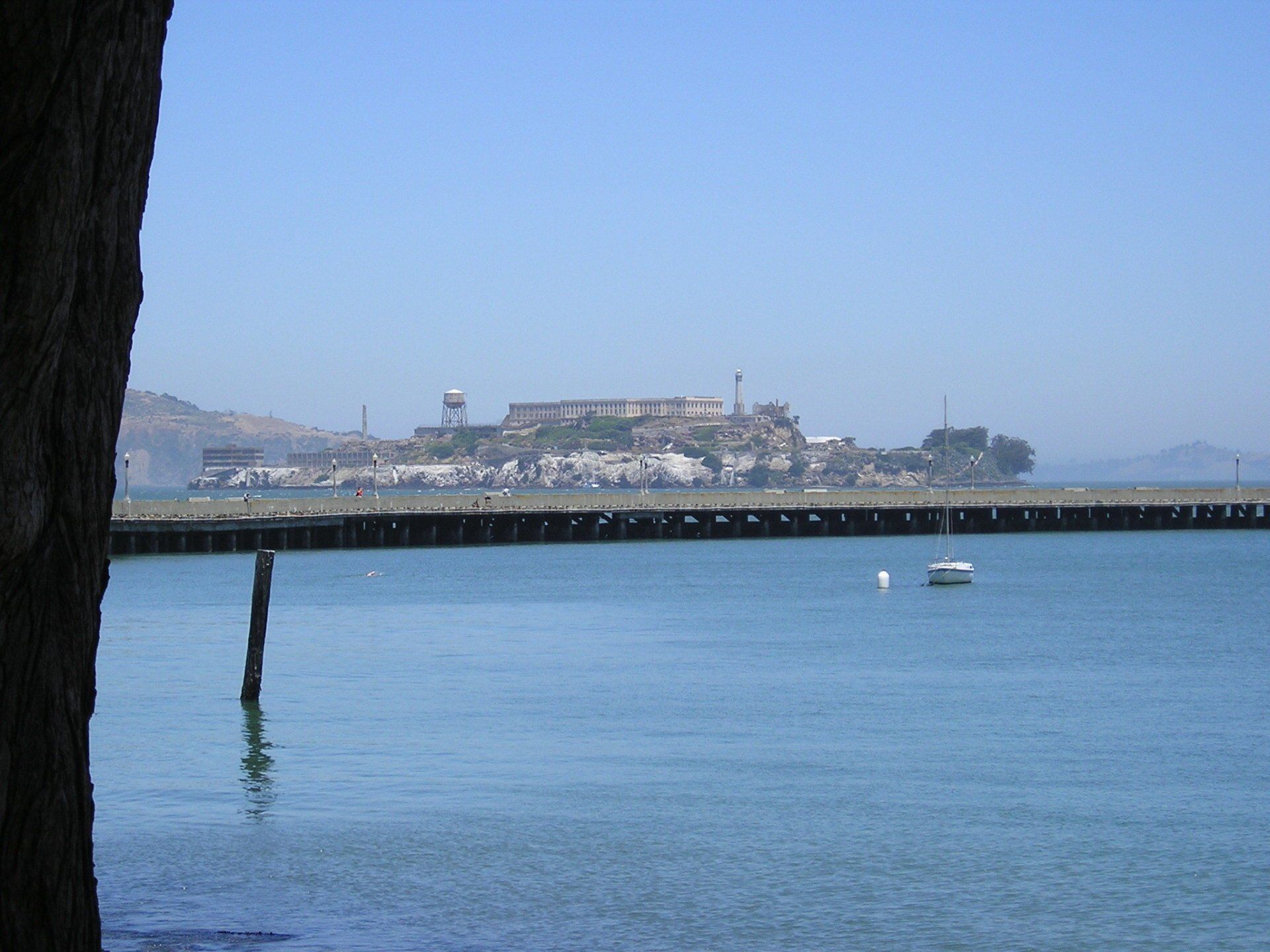 A bridge over a body of water with an island in the background