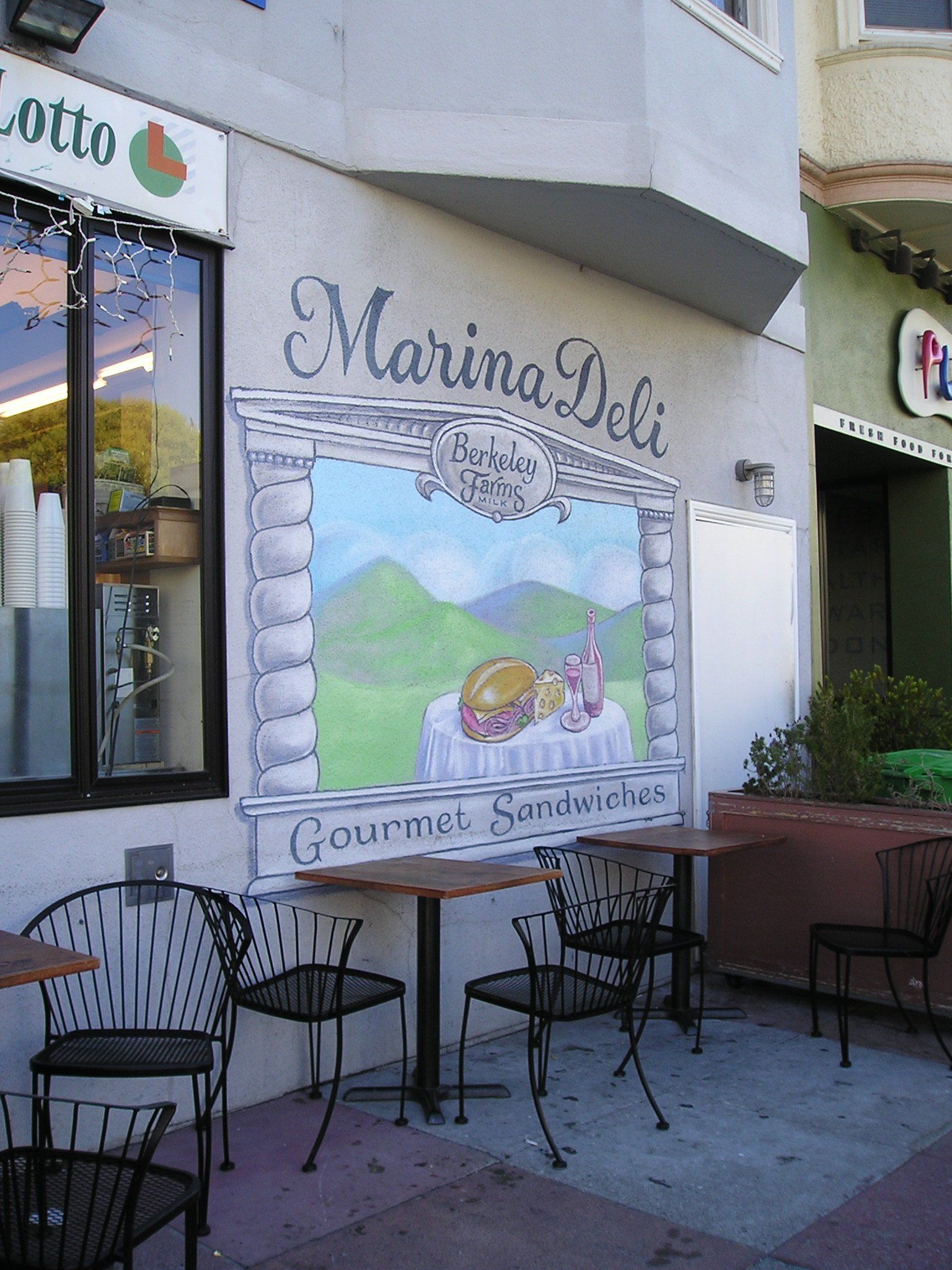 A painting on the side of a building that says marina deli