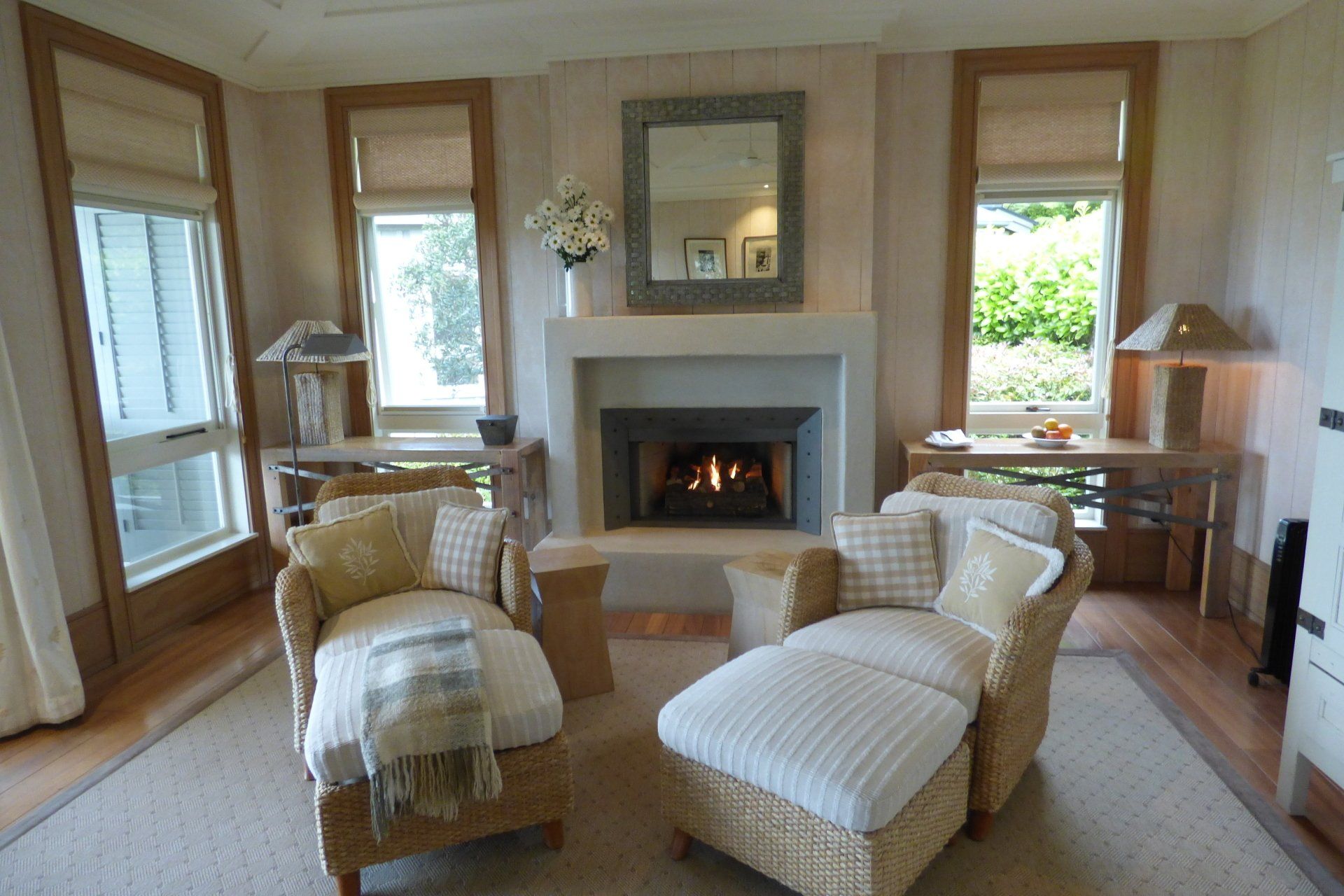 A living room with wicker furniture and a fireplace