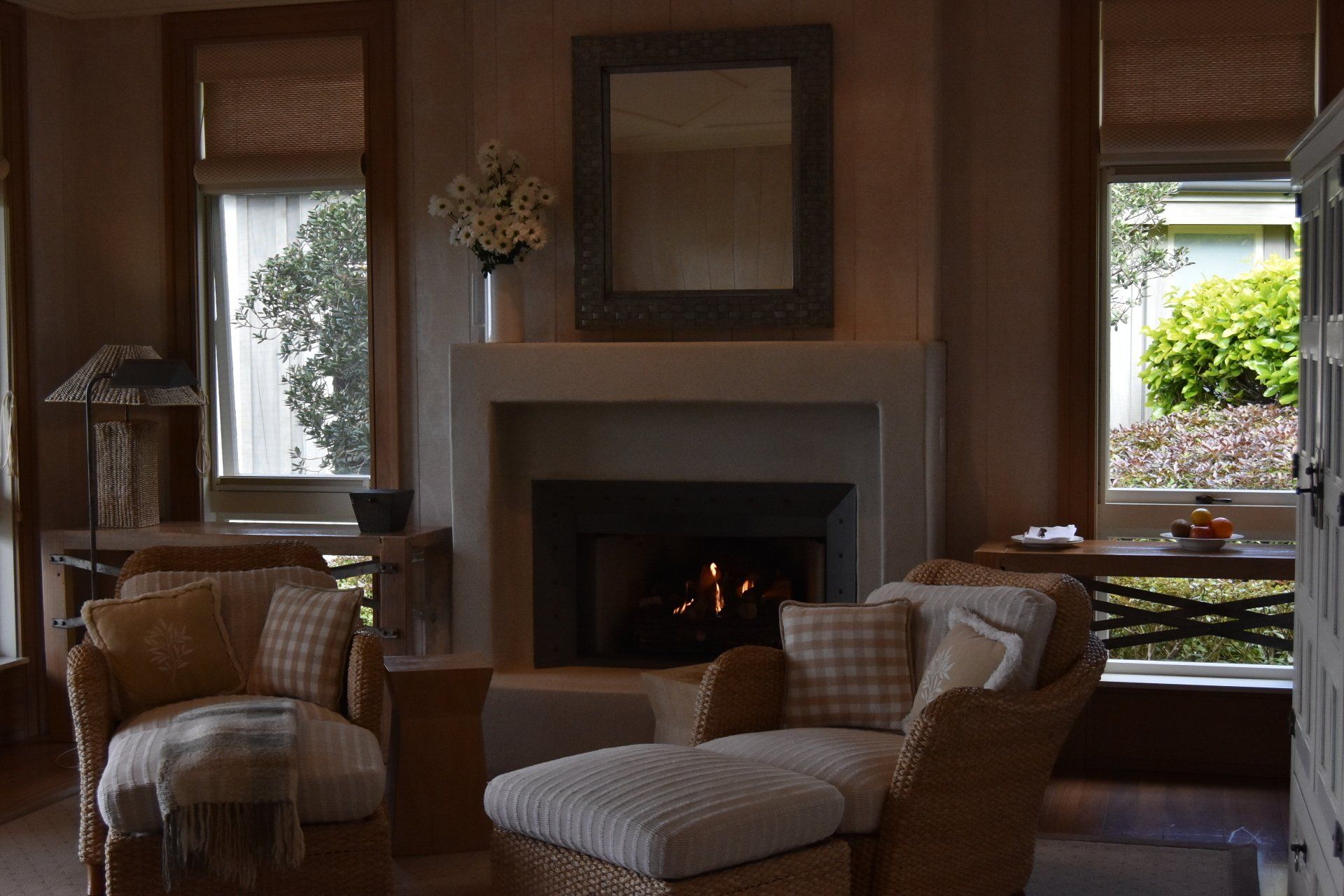 A living room with wicker furniture and a fireplace