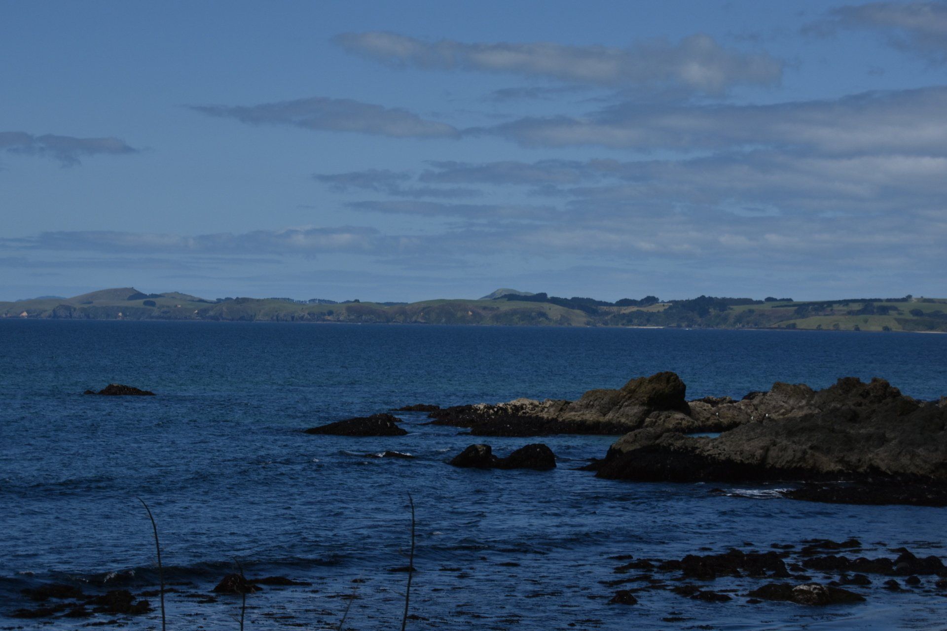 A large body of water with rocks in the foreground