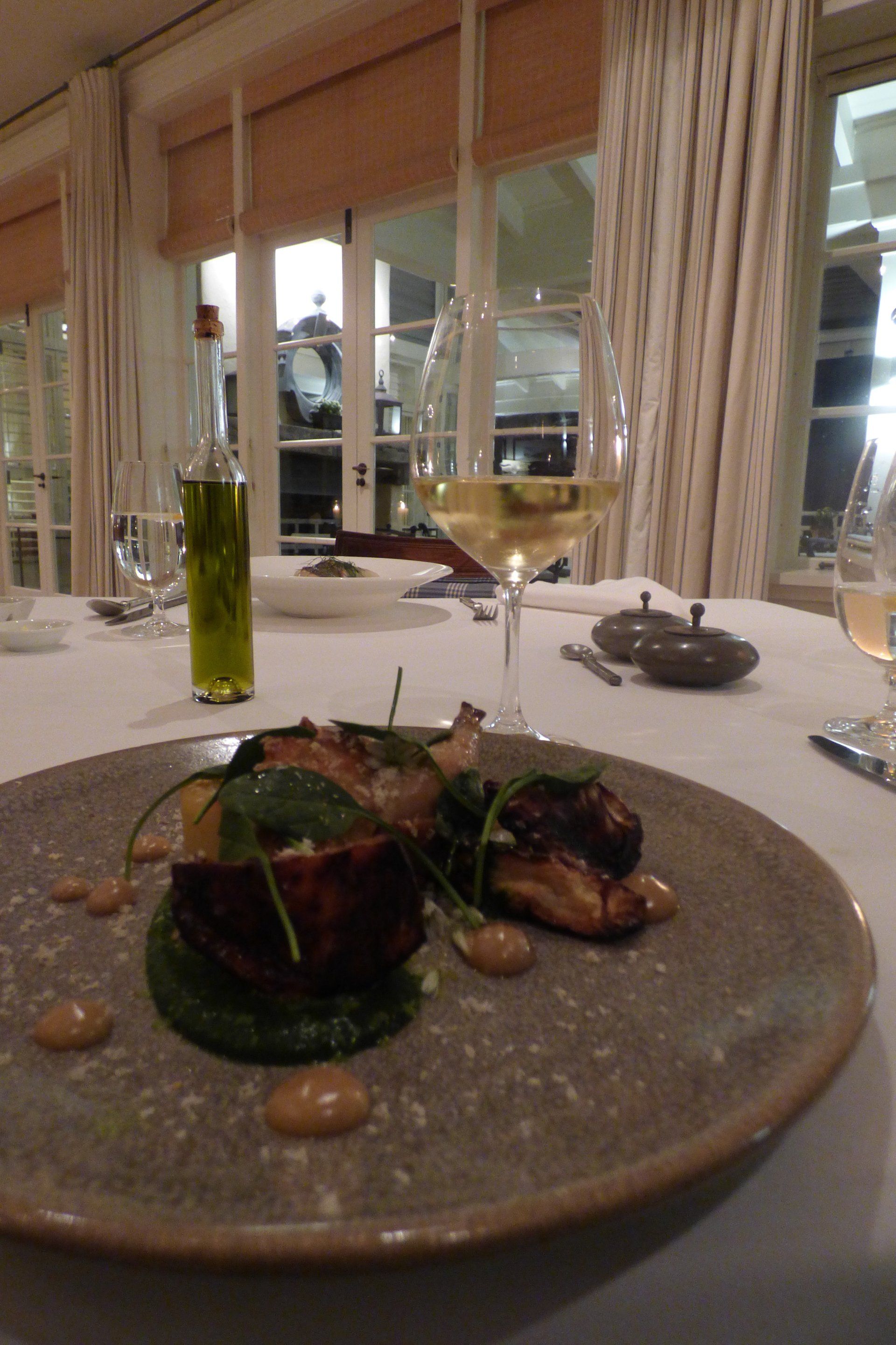 A plate of food and a glass of wine on a table.