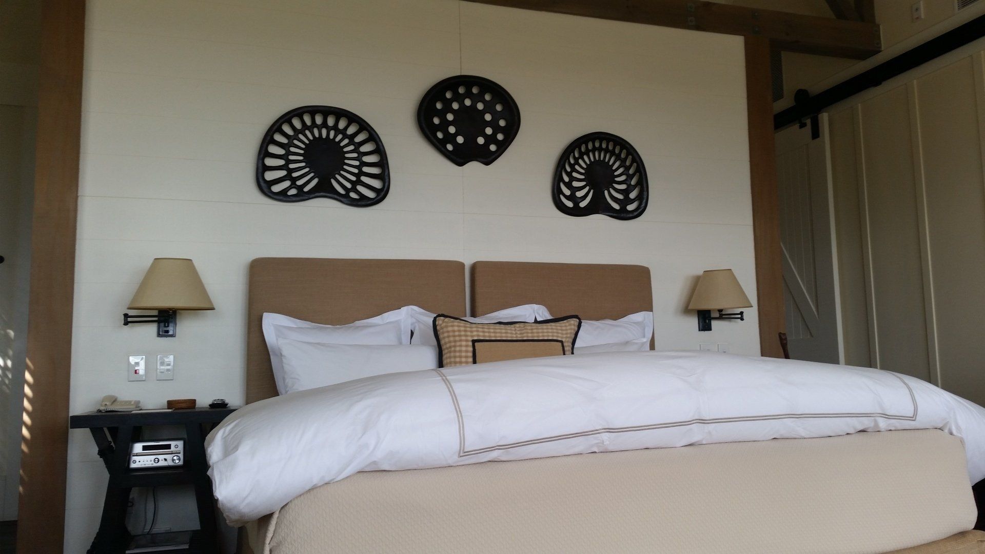 A bedroom with a large bed and two lamps