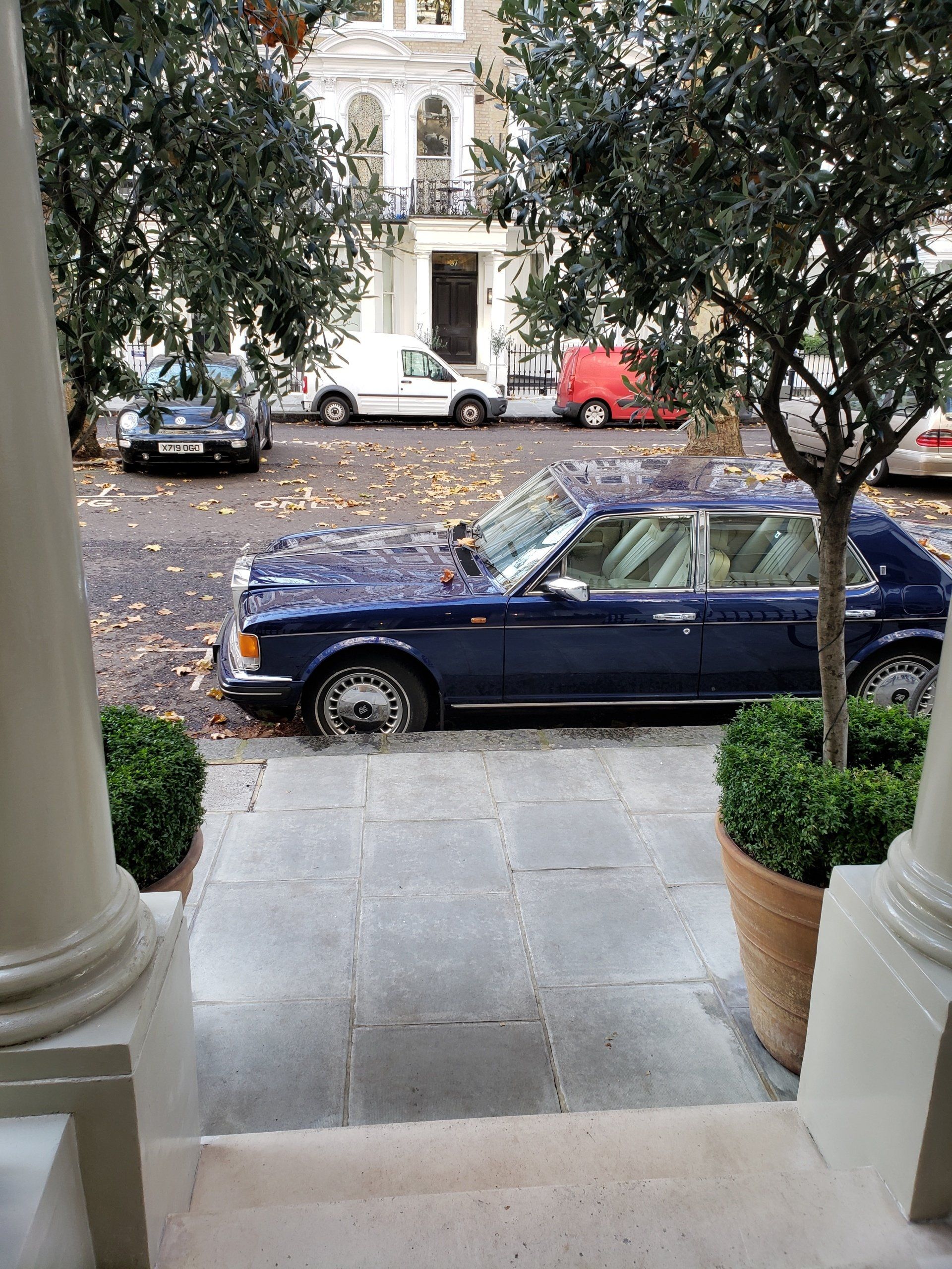 A blue car is parked in front of a building