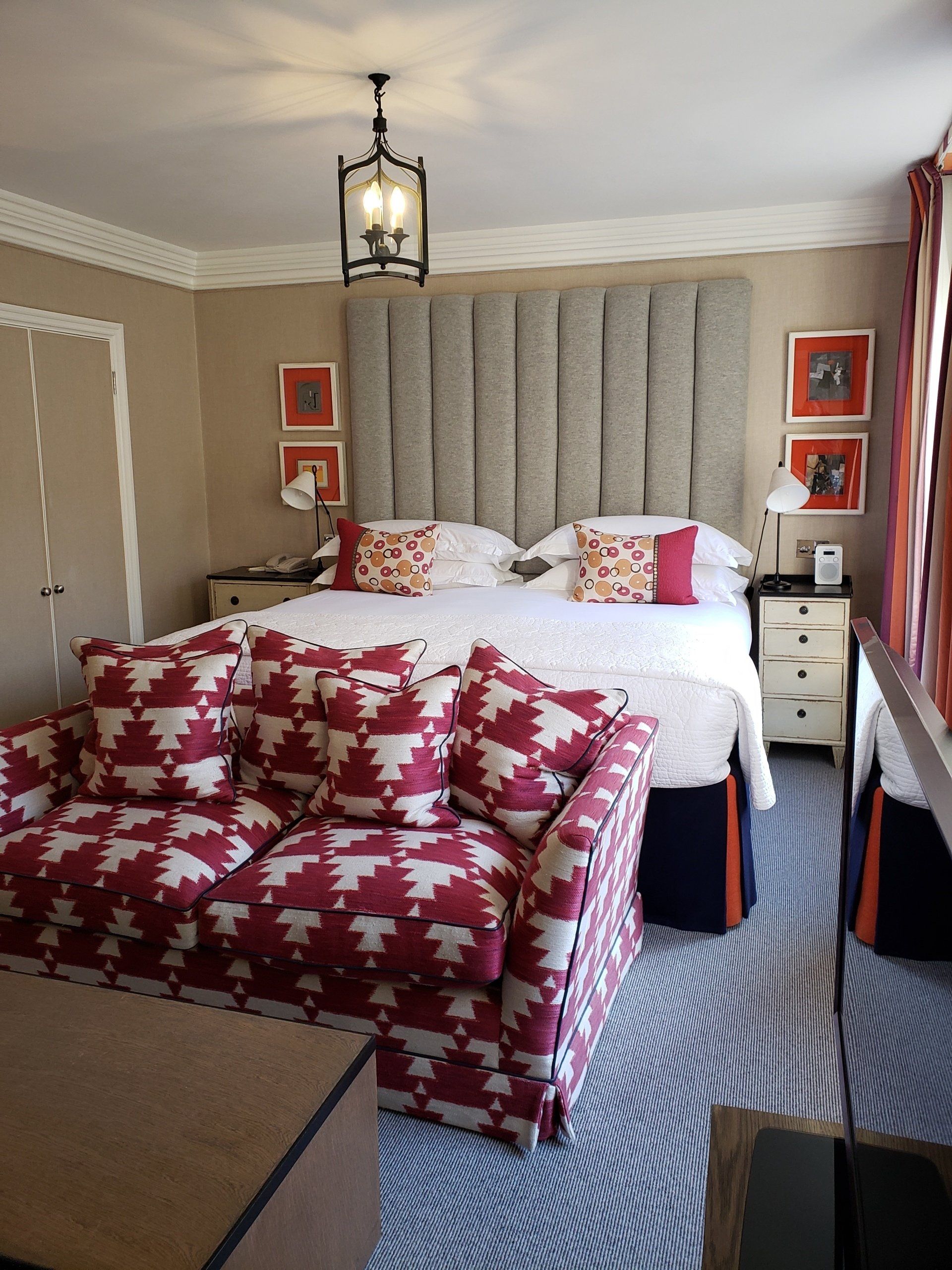 A bedroom with a large bed and a red couch