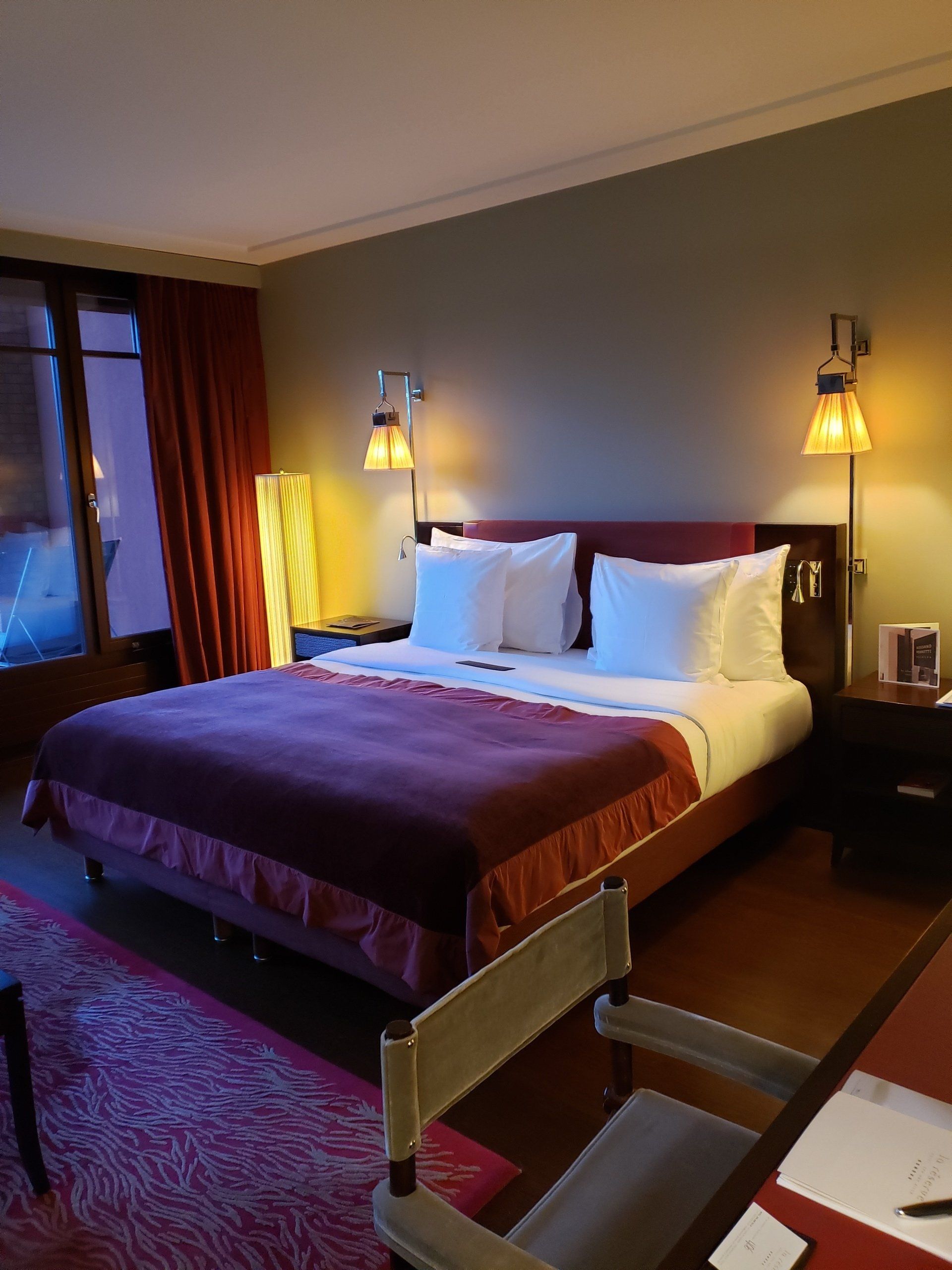 A hotel room with a large bed and a desk