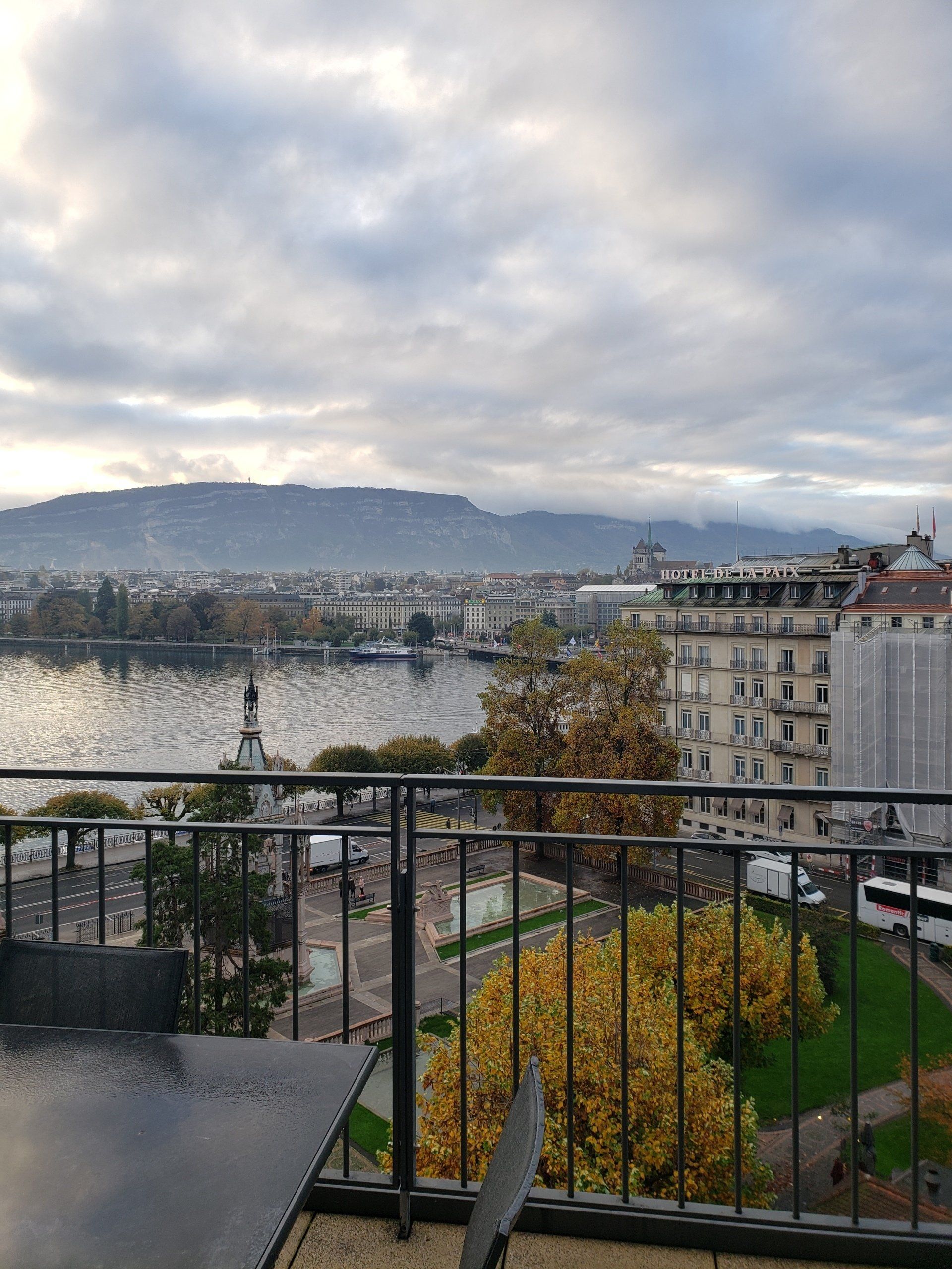 A balcony with a view of a city and a lake.