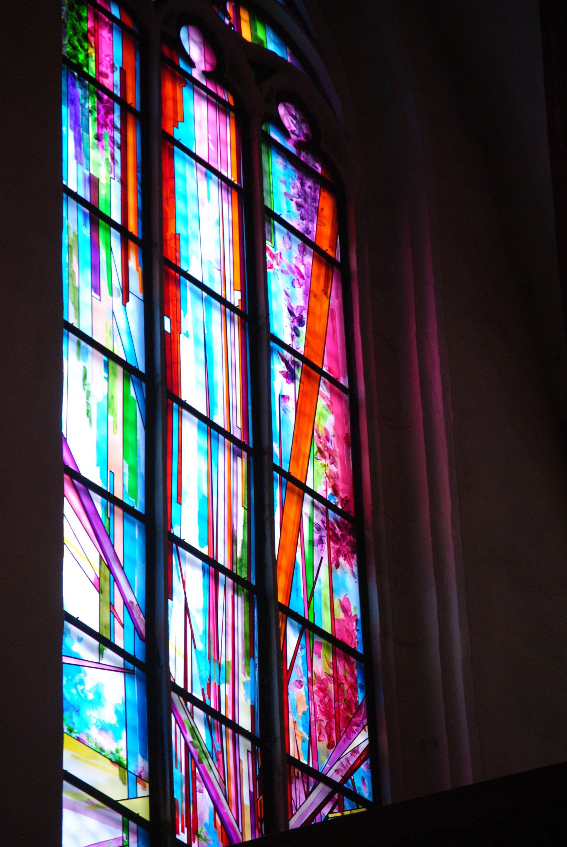 A colorful stained glass window in a dark room