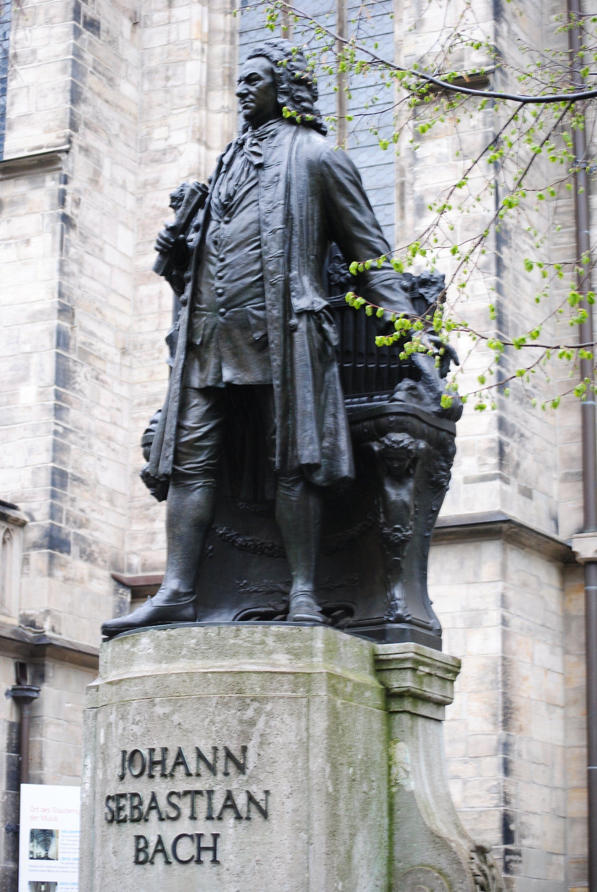 A statue of johann sebastian bach in front of a building