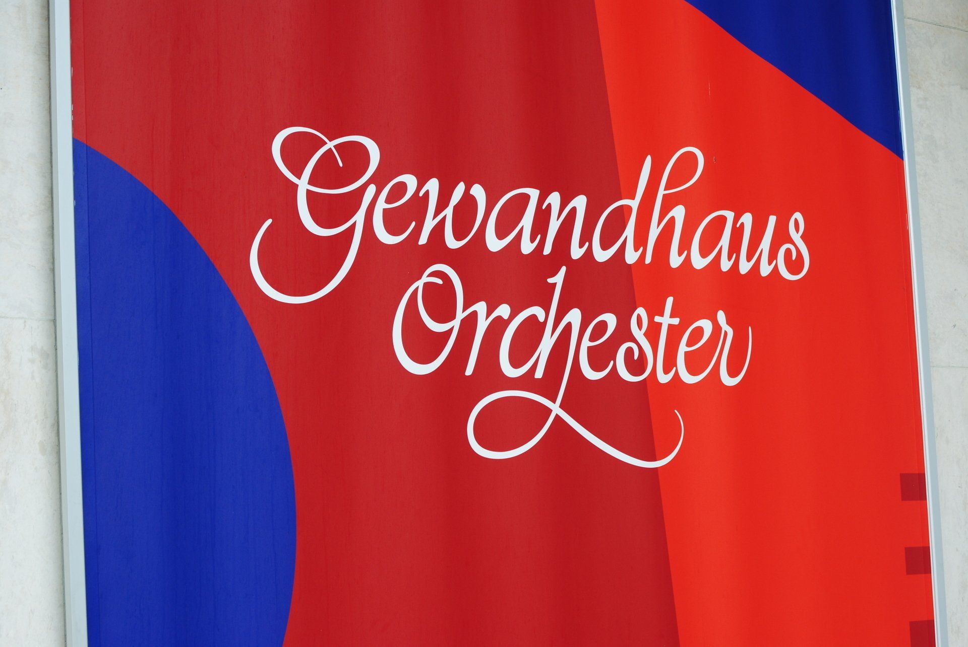 A red and blue banner that says ' gewandhaus orchester ' on it