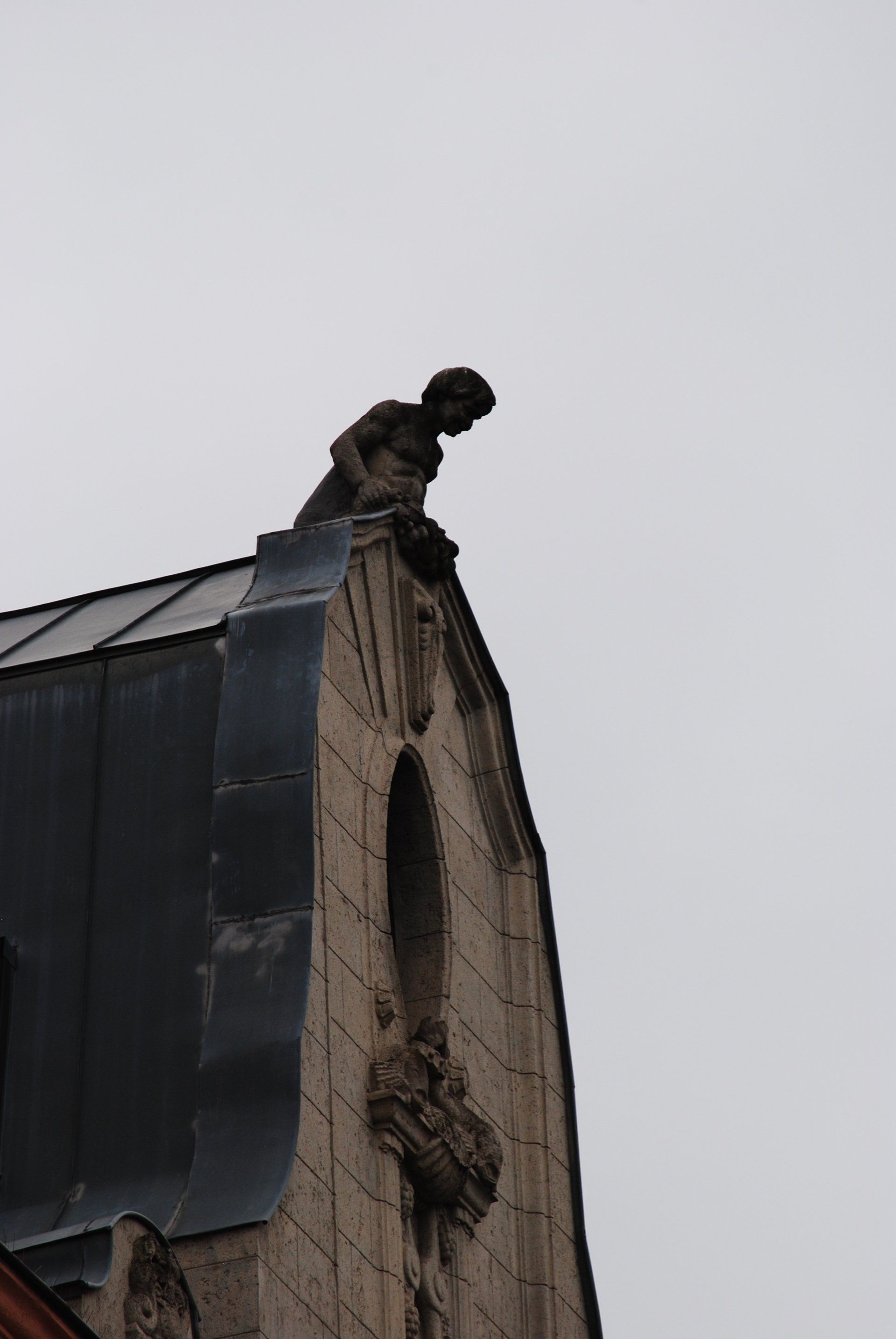 A gargoyle is sitting on top of a building.